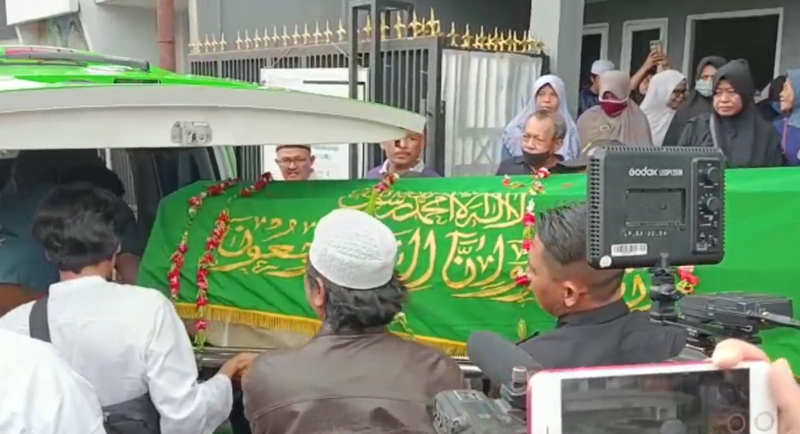 Warga memasukkan keranda berisi senazah Pak Ogah ke ambulans.