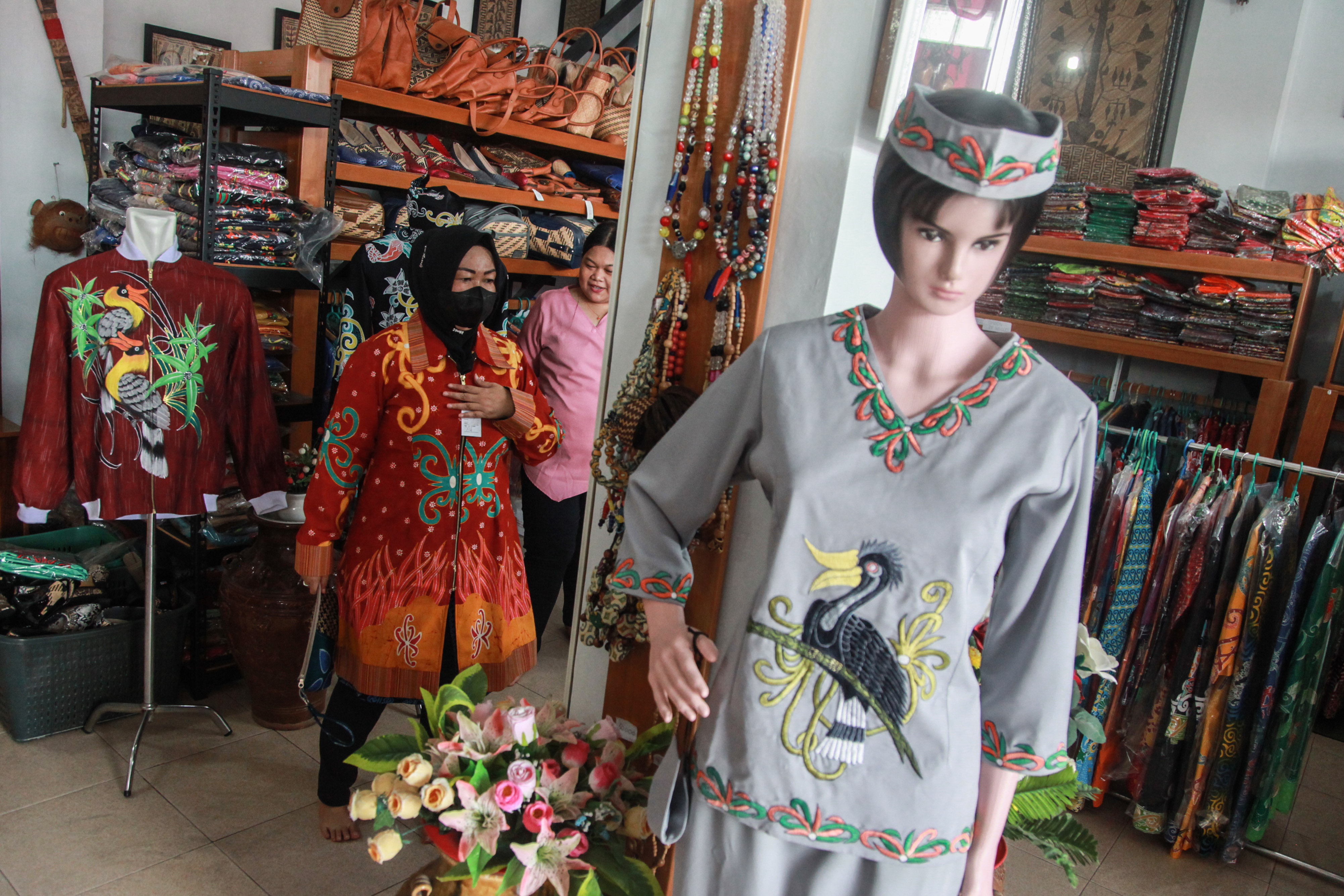 Ilustrasi--Pembeli mencoba pakaian batik motif khas Kalimantan Tengah yang dijual di Toko Moneng Galeri, Palangka Raya, Kalteng.