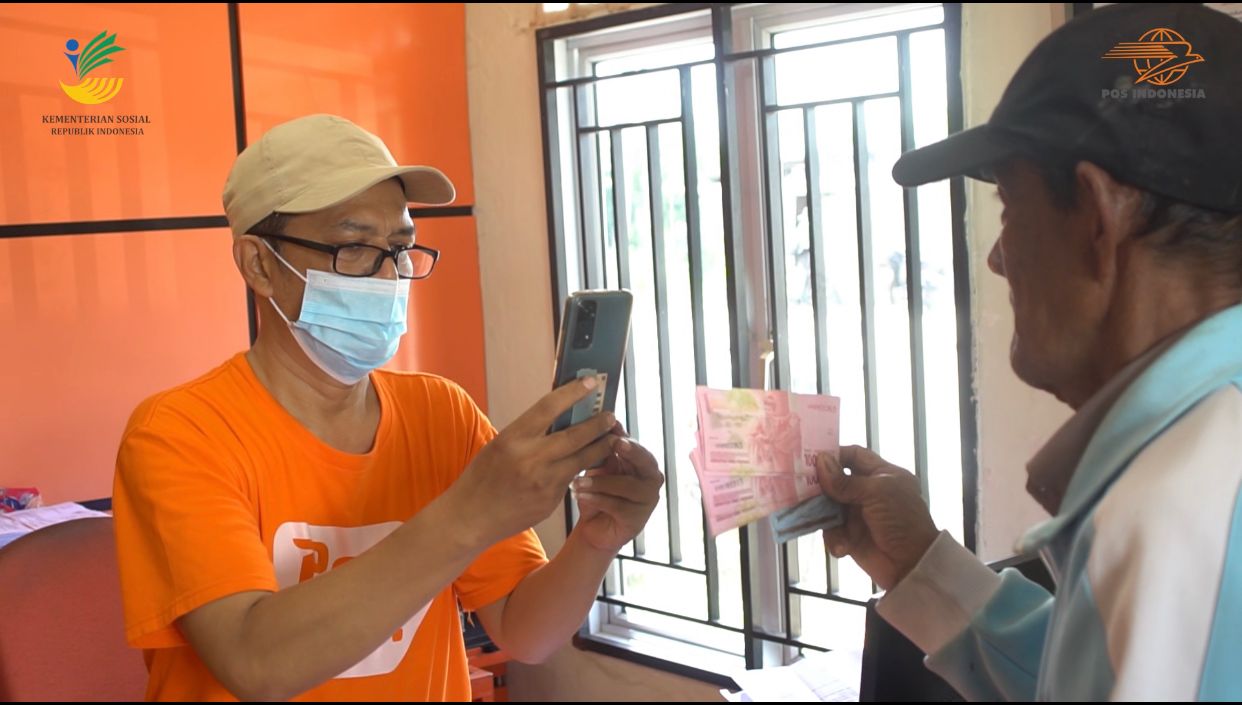 Petugas Pos Indonesia memotret warga yang telah menerima BLT BBM di Kantor Pos.