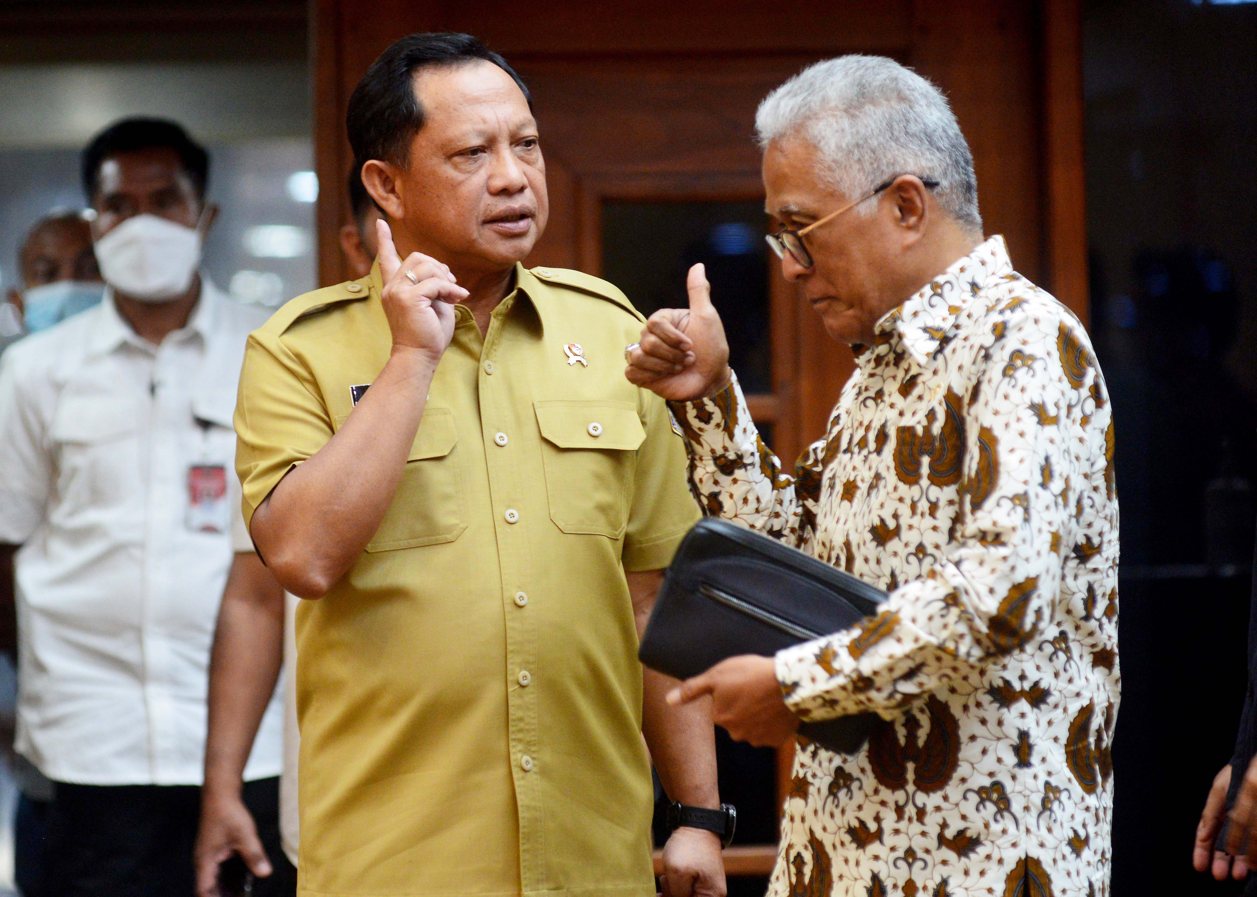 Menteri Dalam Negeri Tito Karnavian (kiri) berbincang dengan anggota Komisi II DPR RI Guspardi Gaus