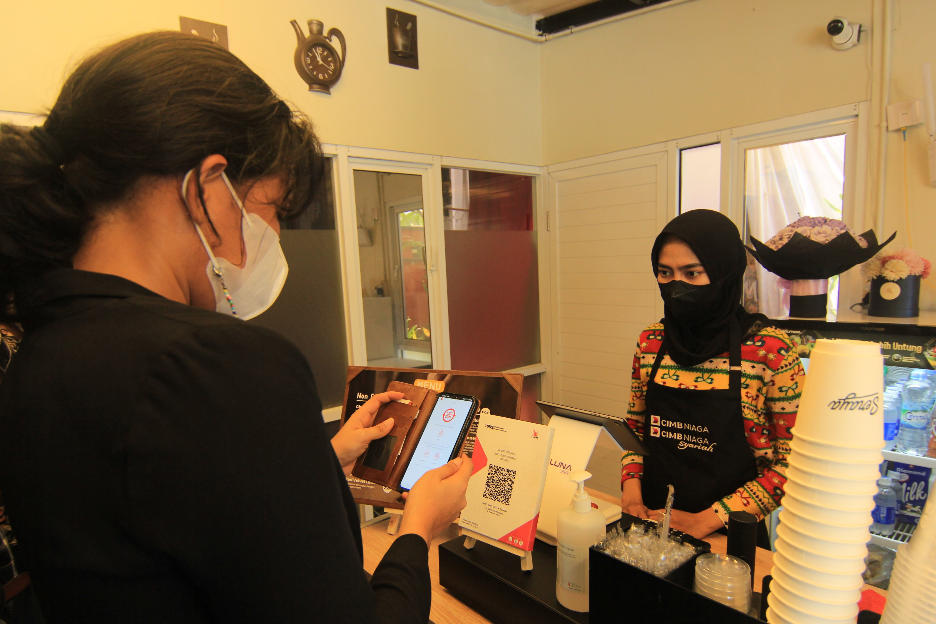 Pelanggan membayar kopi menggunakan fitur pindai QRIS melalui Super App Octo Mobile di Stall Coffee Sando Seraya yang didukung CIMB Niaga