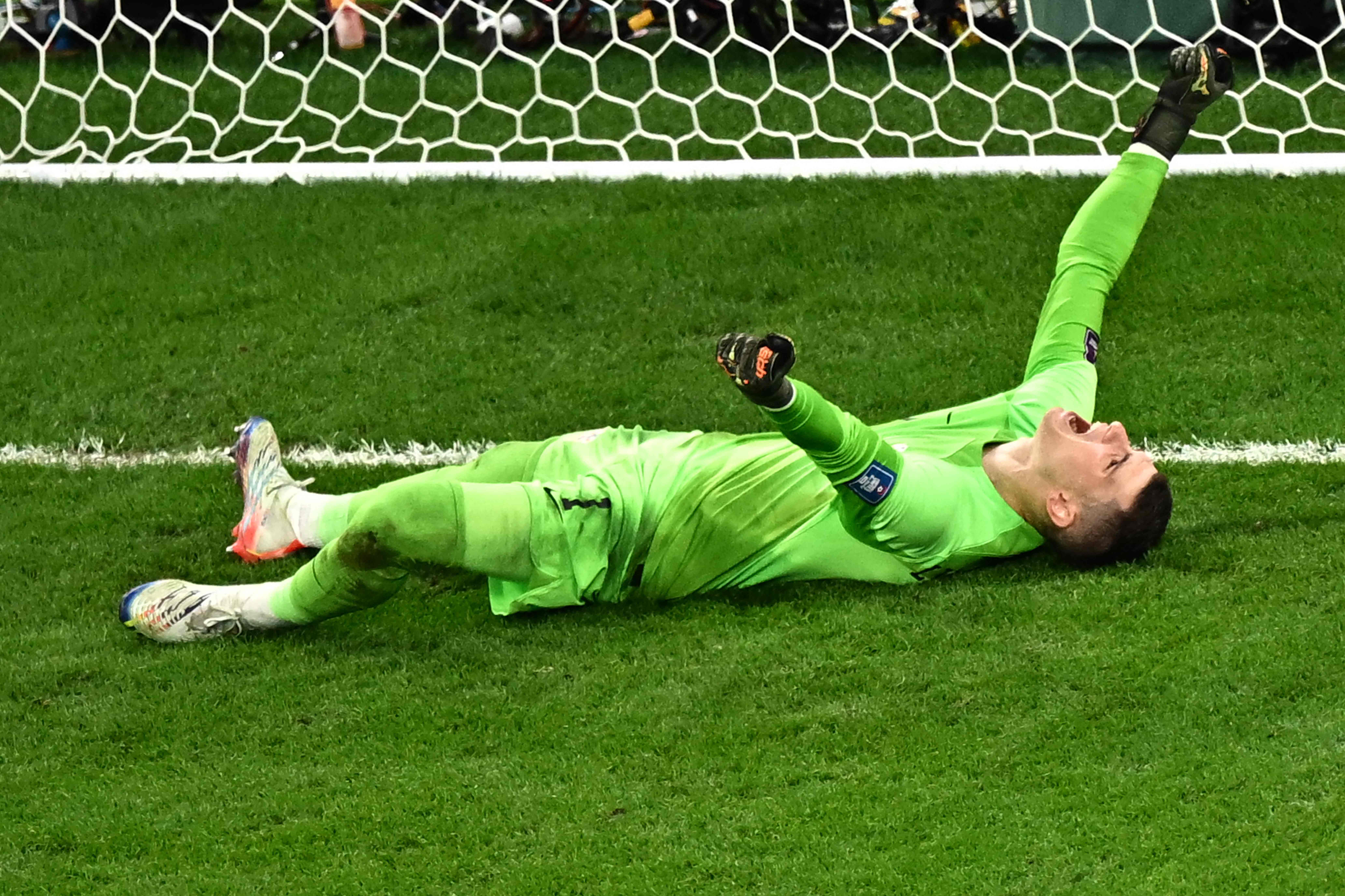 Penjaga gawang Kroasia Dominik Livakovic melakukan selebrasi usai mengalahkan Brasil di laga perempat final Piala Dunia 2022.