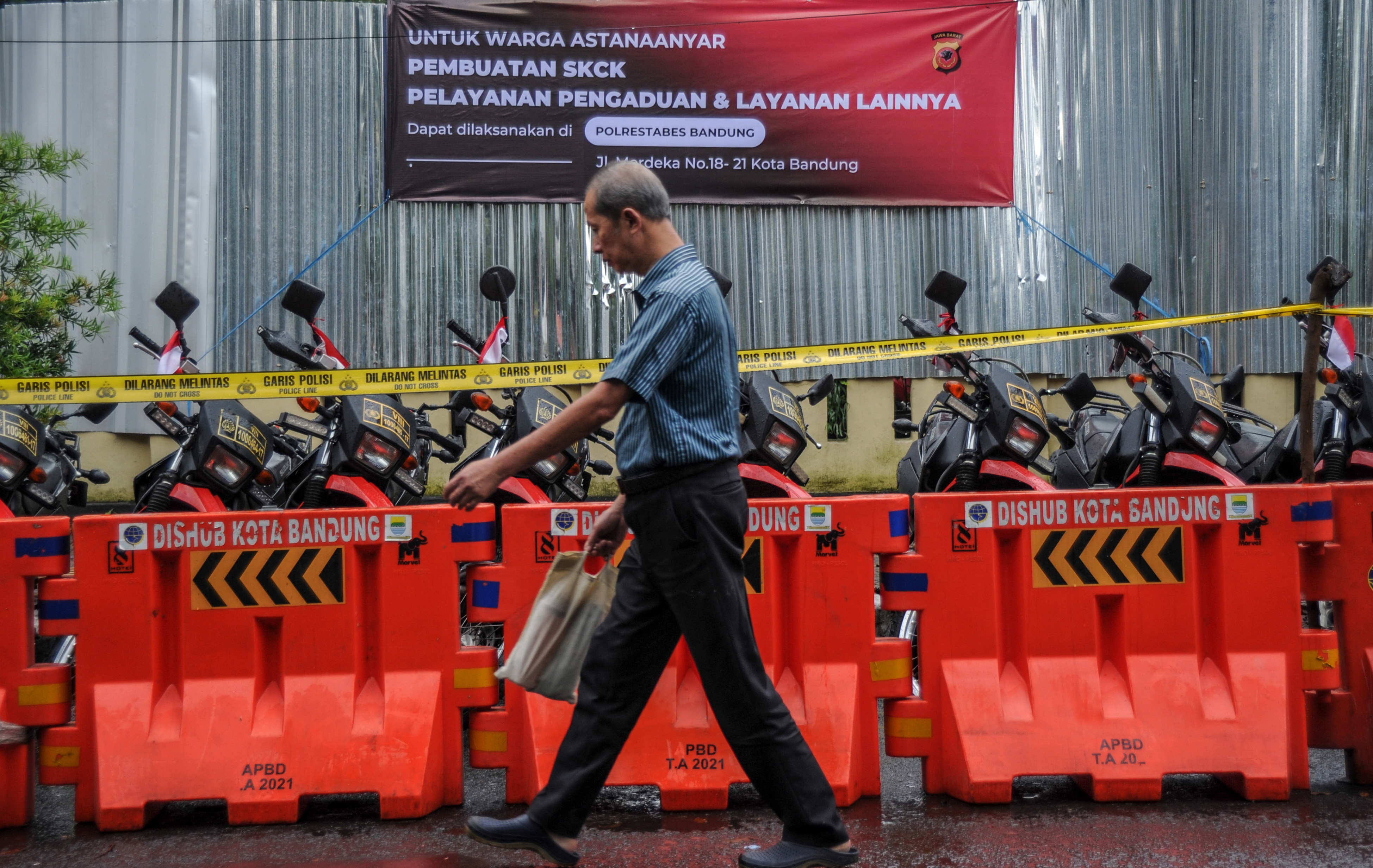 Warga melintas di depan Mapolsek Astanaanyar, Bandung, Jawa Barat, Kamis (8/12), pascaledakan bom bunuh diri yang terjadi Rabu kemarin.