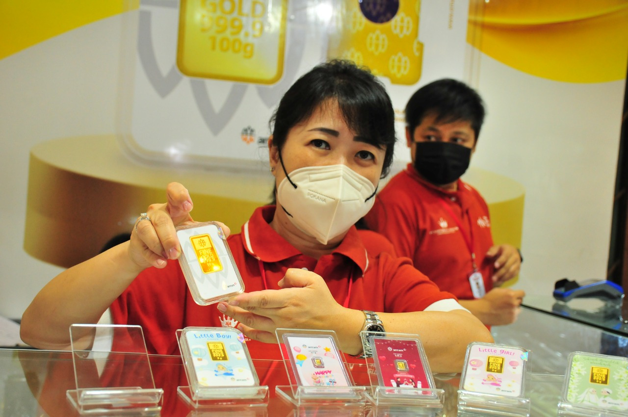 Pelayan menunjukkan emas produk Hartadinata di Jakarta.