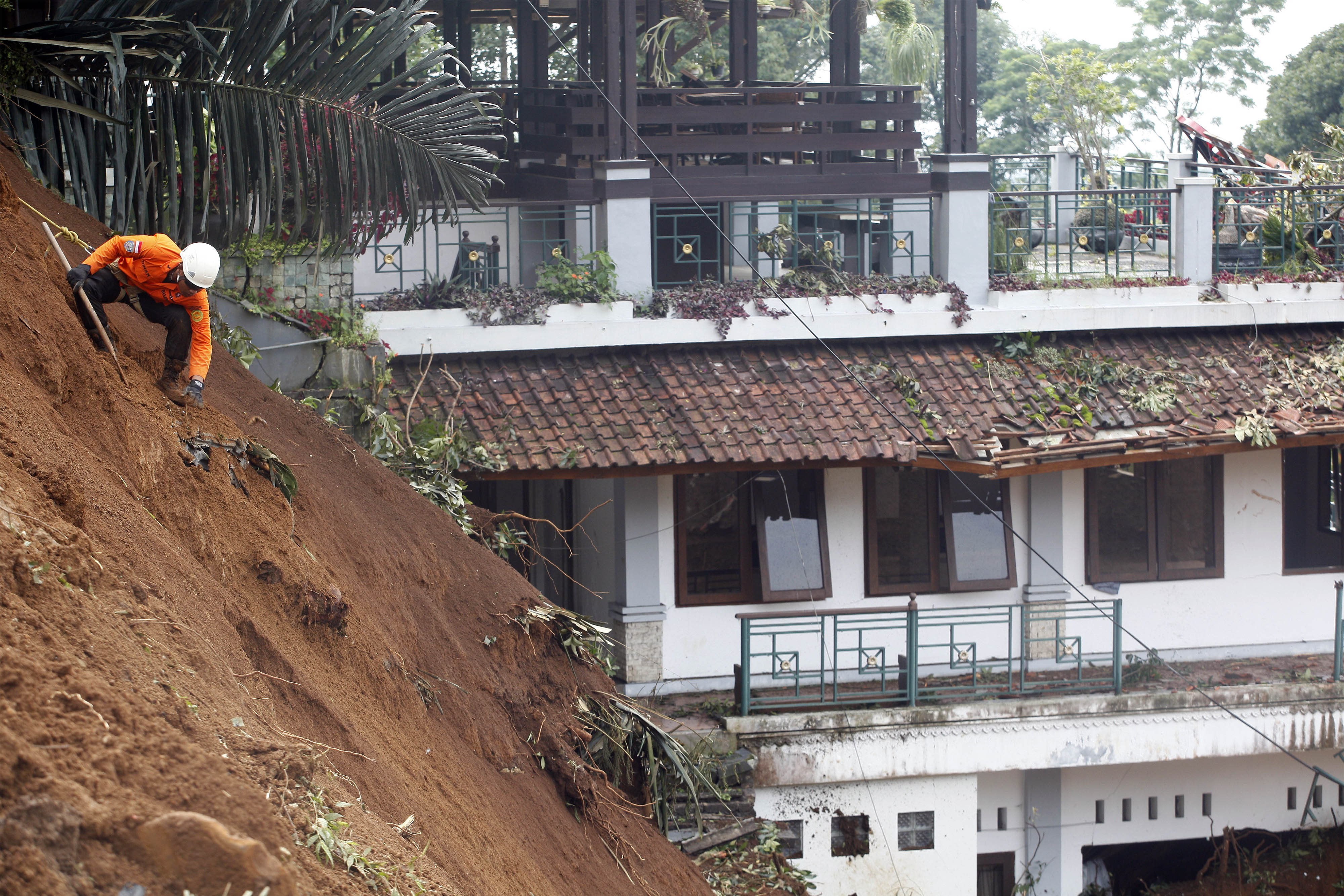 Petugas SAR gabungan melakukan evakuasi mobil yang tertimbun longsor akibat gempa di Cugenang, Kabupaten Cianjur, Jawa Barat, Kamis (24/11).