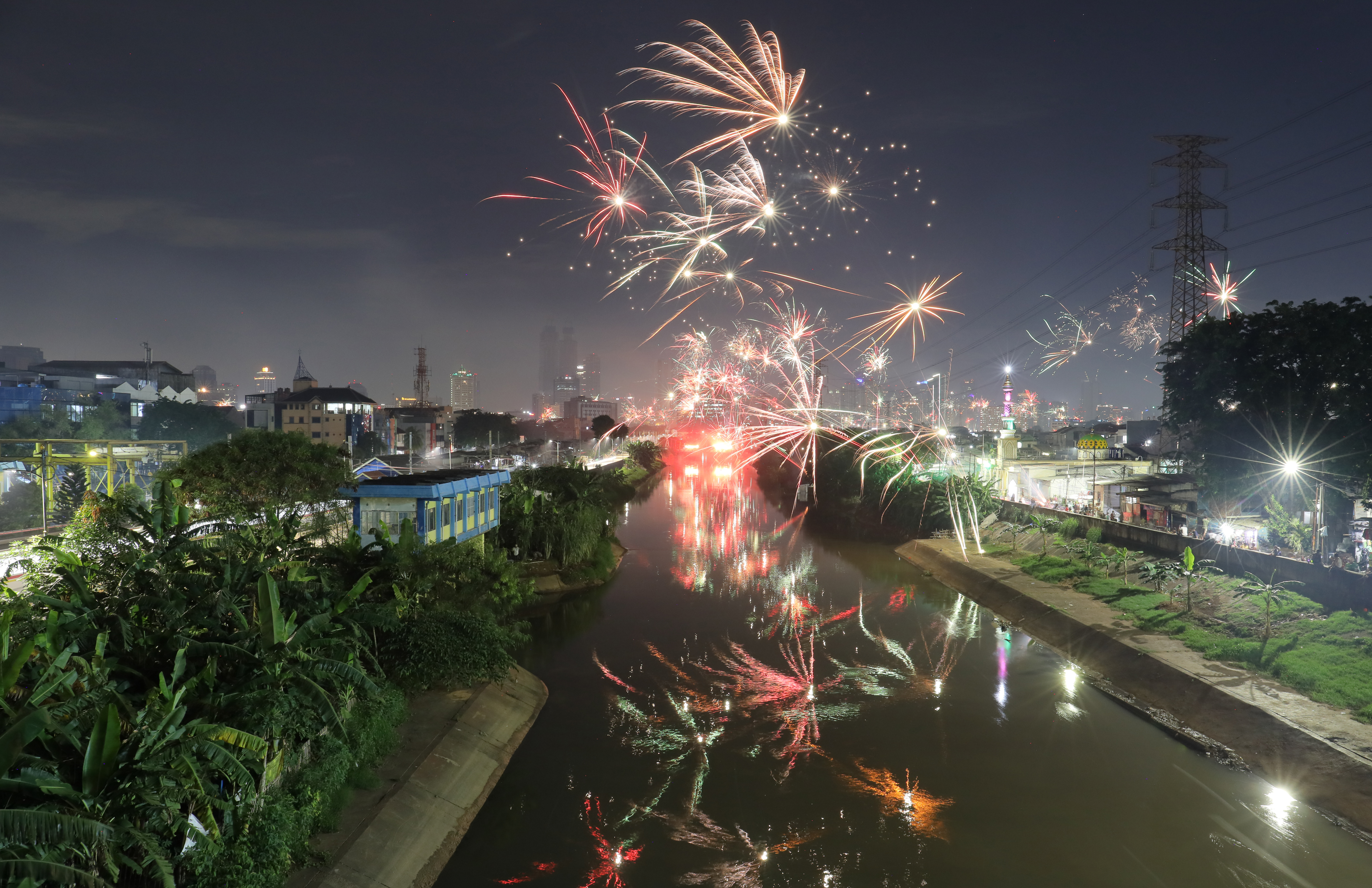 Suasana kota Jakarta yang dihiasi kembang api saat malam pergantian tahun baru 2022 dari kawasan Tomang, Jakarta