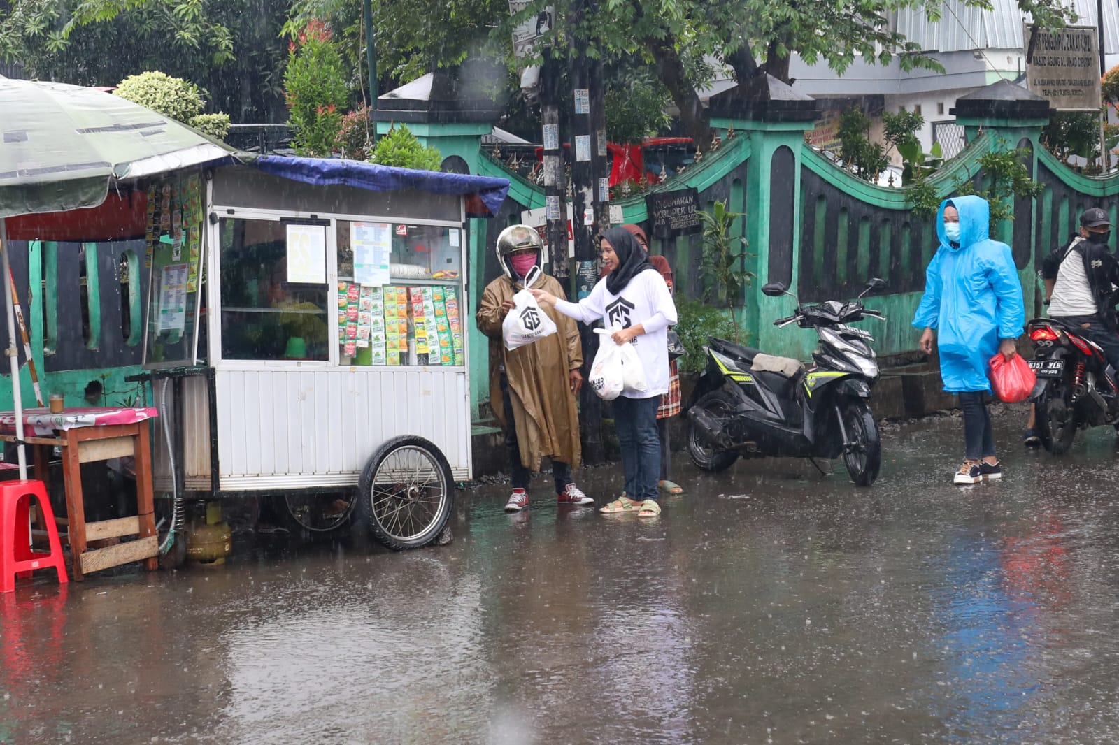 Hujan tak surutkan relawan Gardu Ganjar membagikan sembako ke kalangan yang berhak di Tangsel, Banten, Senin (26/12/2022)