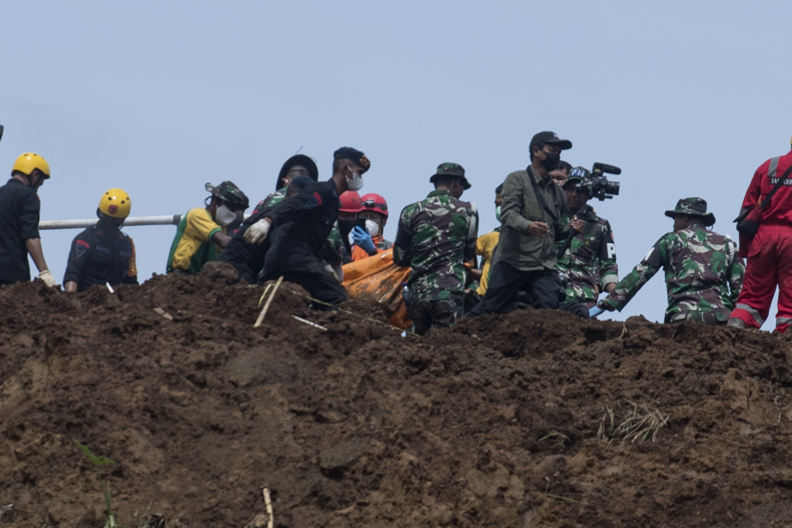 Tim SAR gabungan membawa kantong berisi jenazah korban yang tertimbun longsor akibat gempa di Kampung Cijedil, Cugenang, Minggu (27/11). 