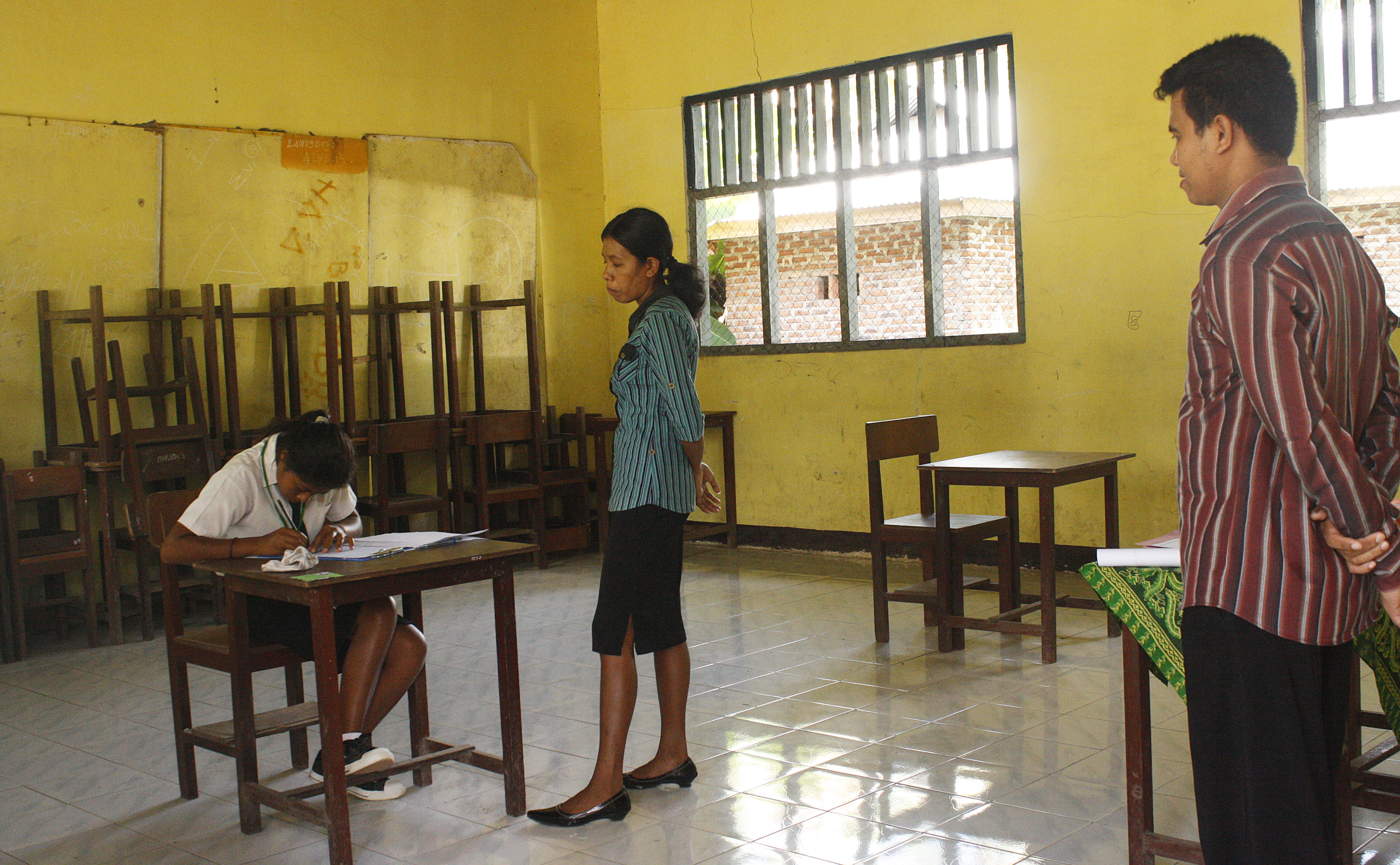 Dua guru di Lembata, Nusa Tenggara Timur, tengah mengawasi seorang murid mengerjakan soal ujian 