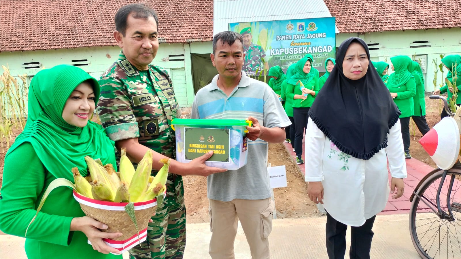 Prajurit Yon Bekang 3/Rat membagikan hasil panen jagung ke warga