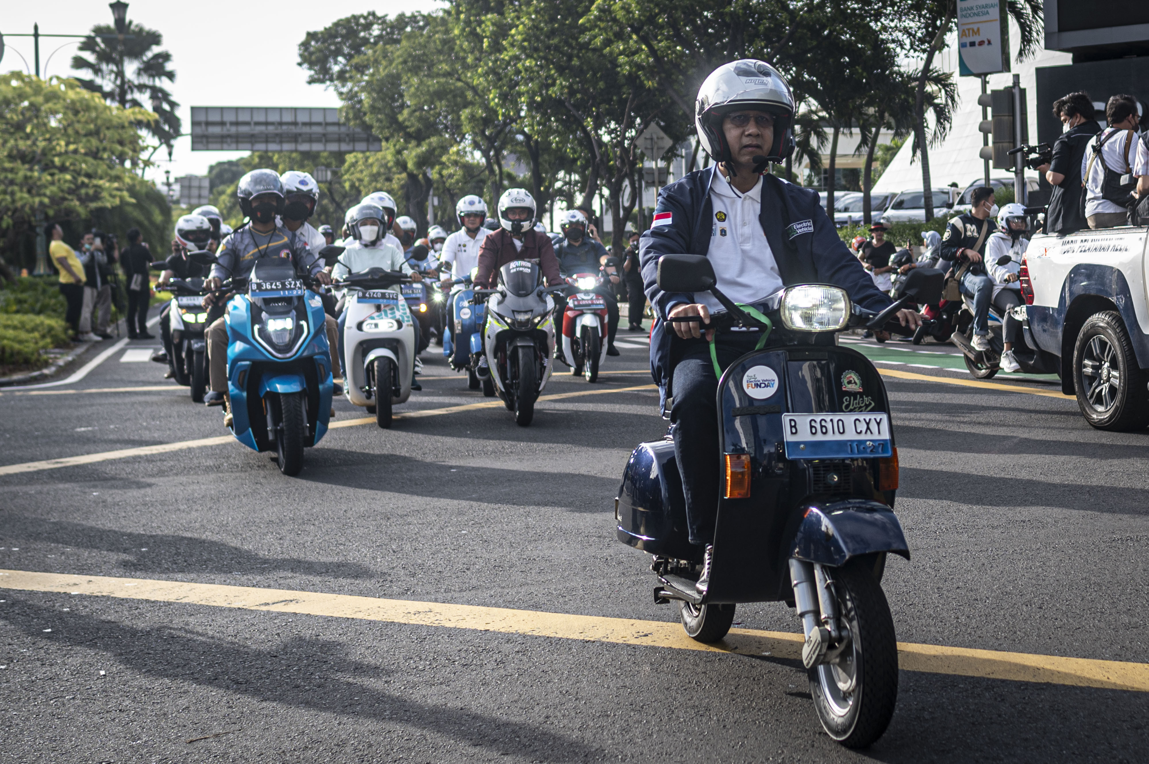 Penjabat Gubernur DKI Jakarta Heru Budi Hartono (kanan) mengendarai vespa listrik 