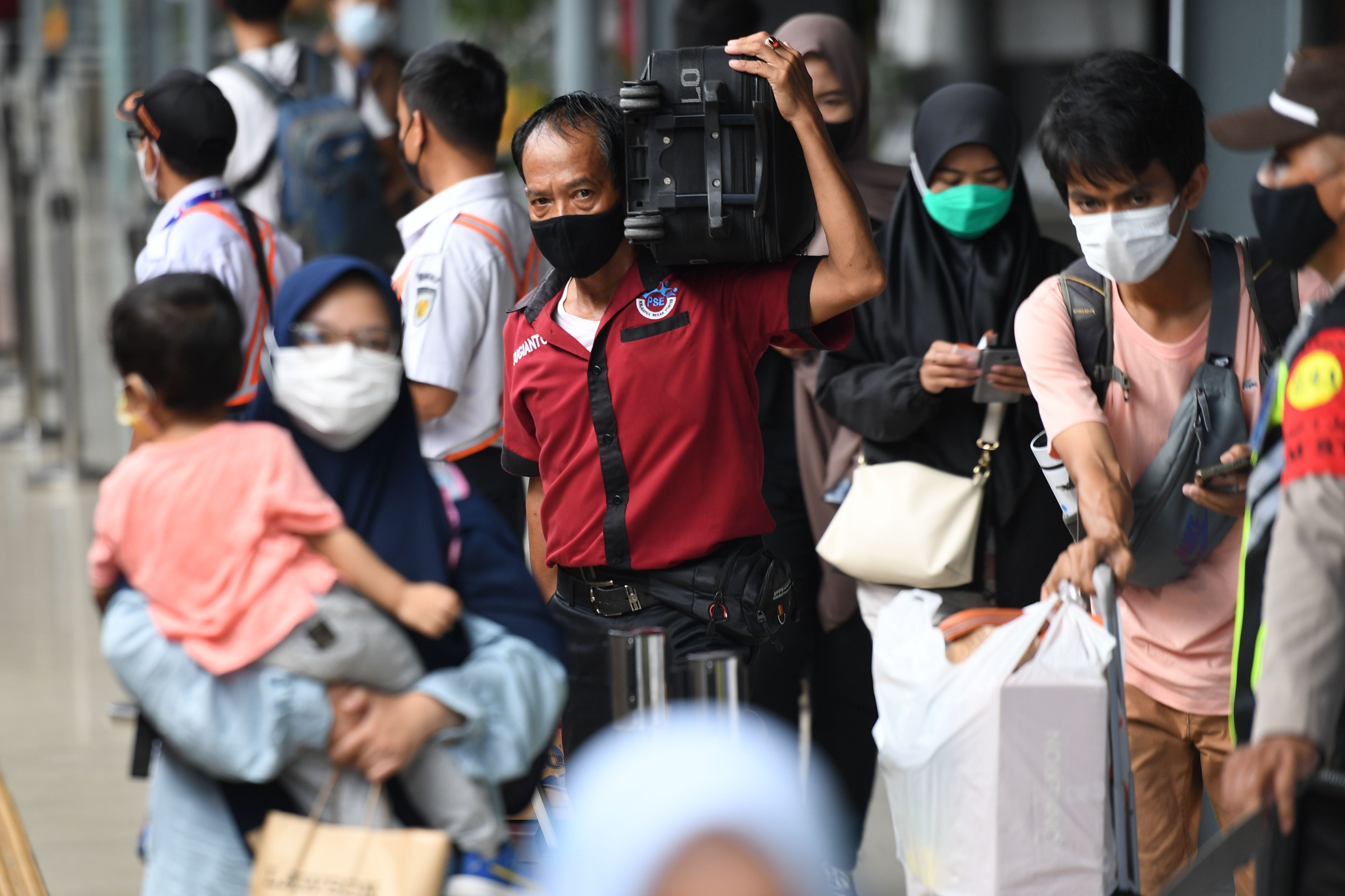 Porter membawa barang bawaan penumpang kereta api di Stasiun Pasar Senen, Jakarta.