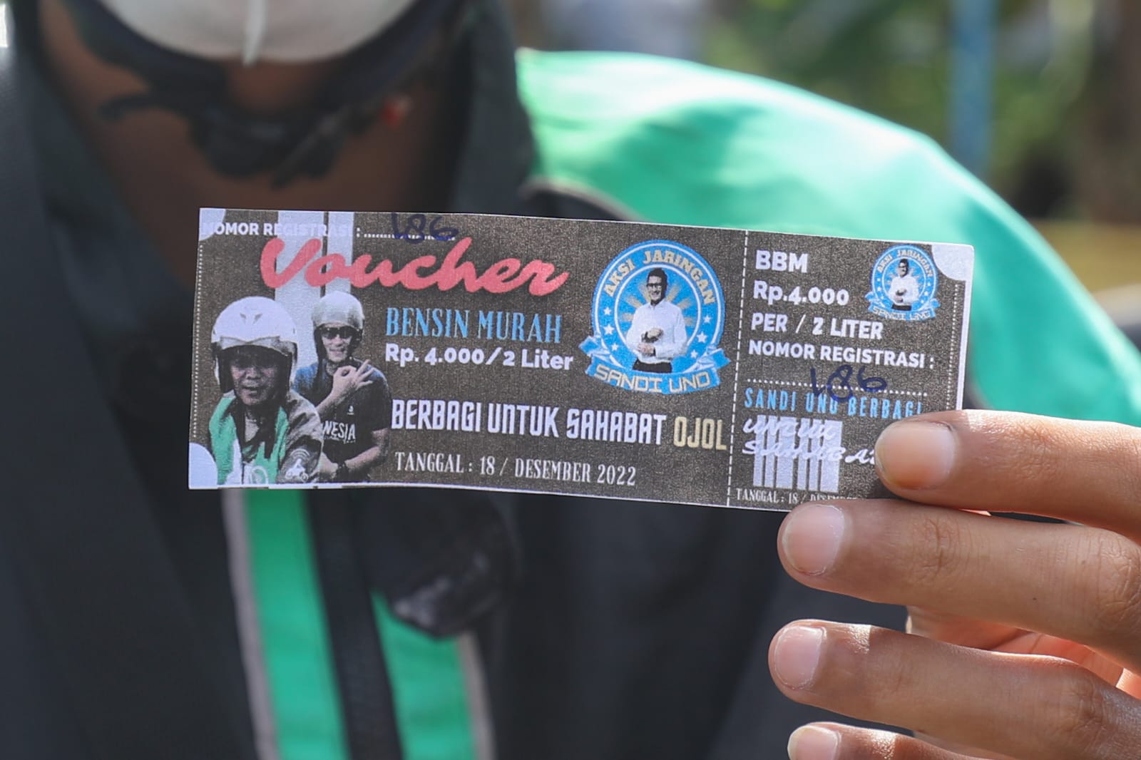 Pengemudi ojol memperlihatkan voucer subsidi BBM yang diberikan Aksi Jaringan Sandi Uno Jakarta Barat, Minggu (18/12/2022)