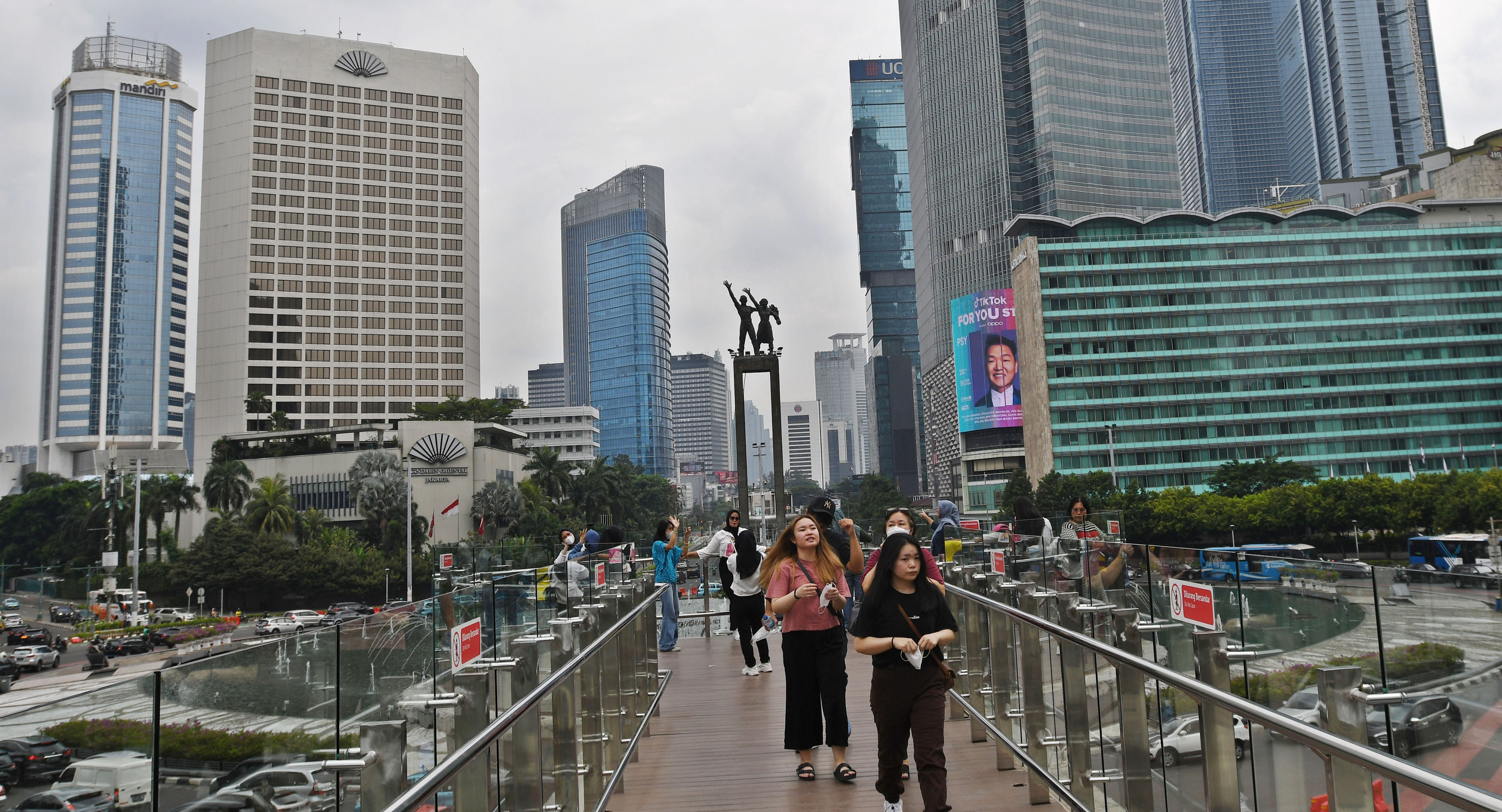 Sejumlah warga menikmati suasana Bundaran Hotel Indonesia (HI) di anjungan Halte Bus Trans Jakarta Bundaran HI, Jakarta.