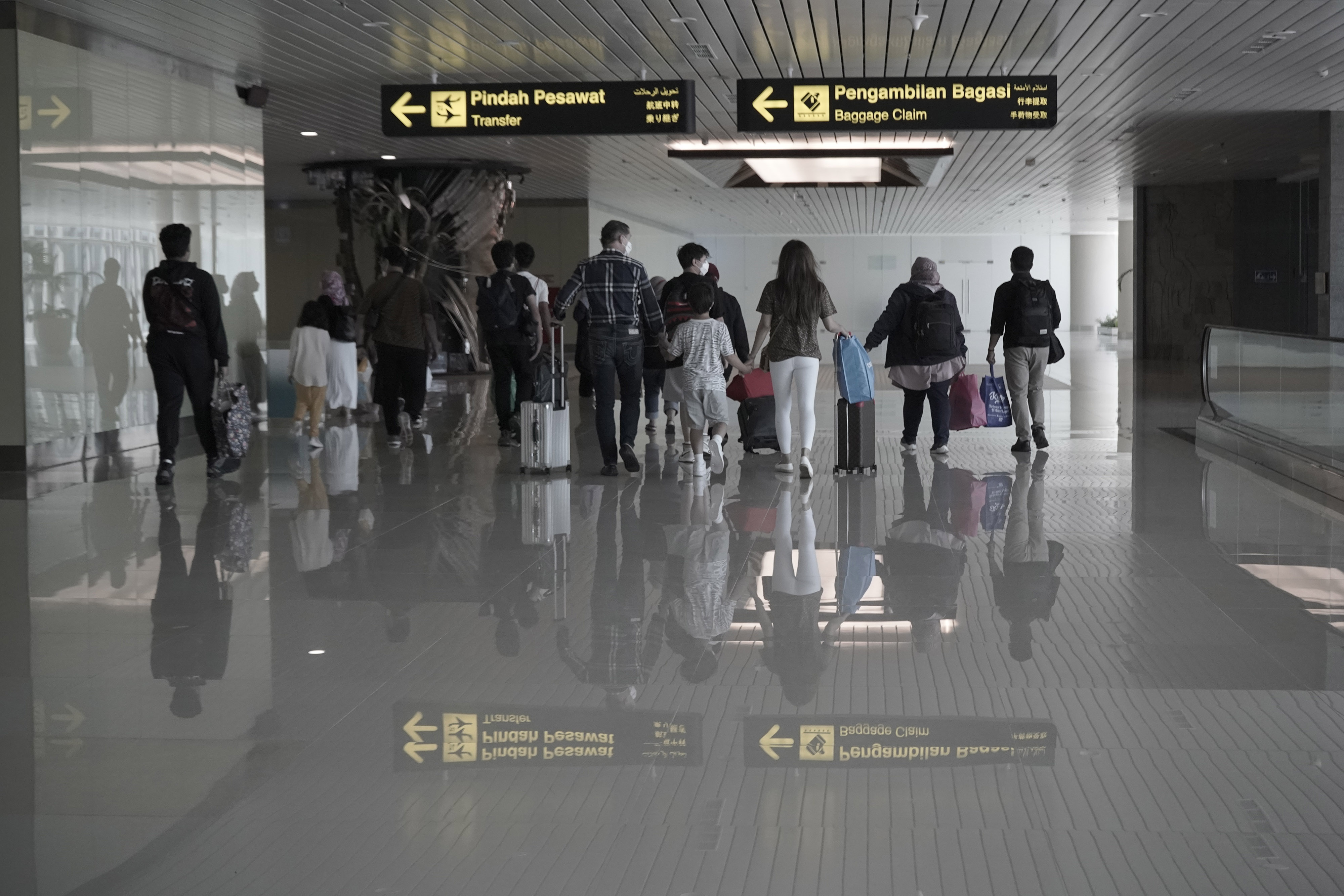 Sejumlah penumpang pesawat berjalan di bandara internasional Ngurah Rai, Badung, Bali, jelang libur Natal dan Tahun Baru 2022.