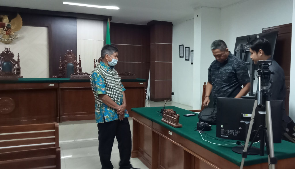 Terdakwakasus dugaan pelanggaran HAM berat Periswtiwa Paniai Mayor Inf (Purn) Isak Sattu berkonsultasi dengan kuasa hukumnya, Senin (21/11).