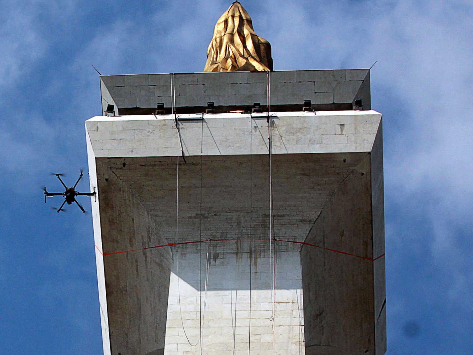 Pekerja membersihkan salah satu sisi Tugu Monumen Nasional (Monas) menggunakan air panas bertekanan tinggi pada 2014.