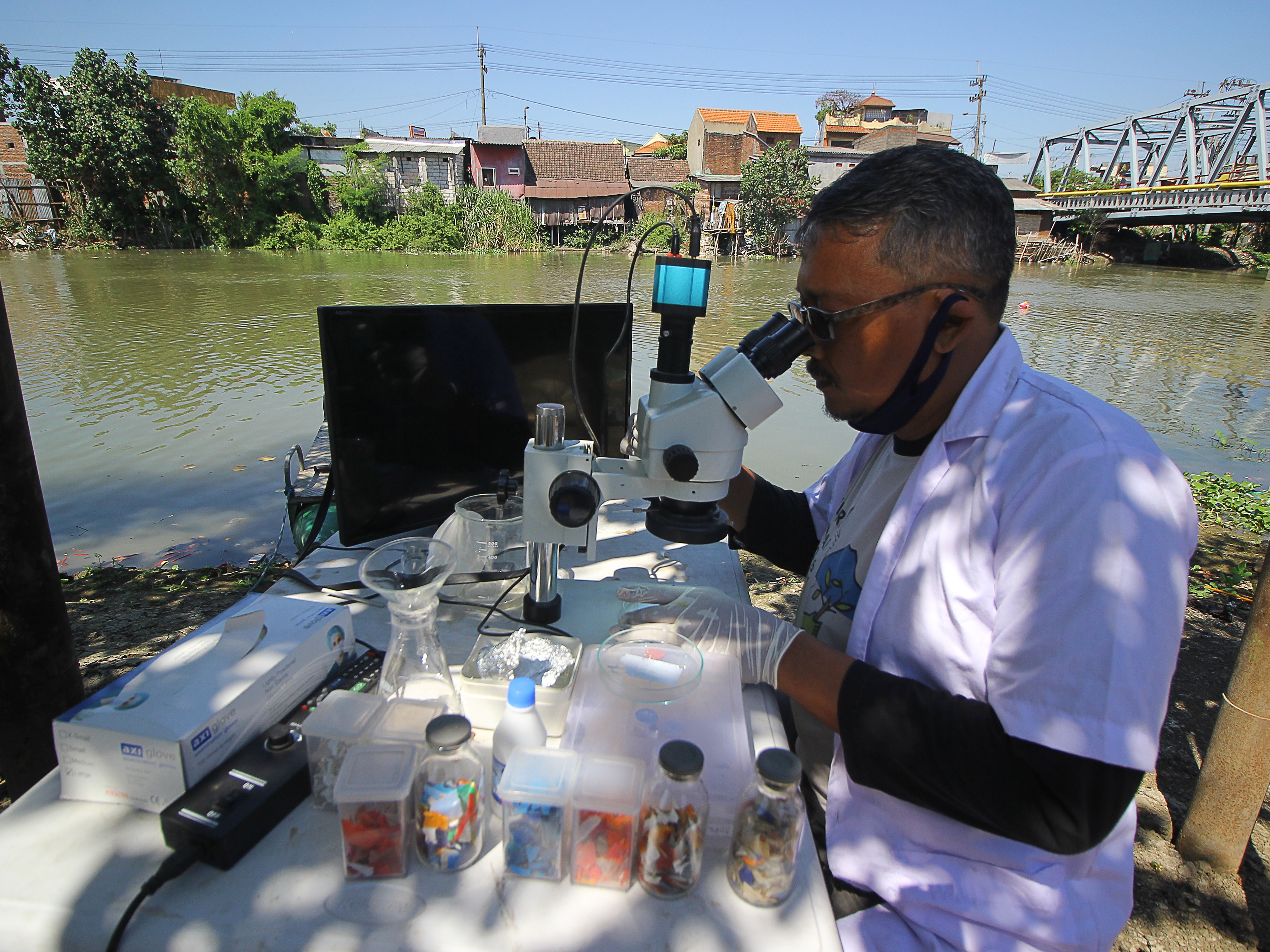 Anggota tim peneliti dari Ecological Observation and Wetlands Conservation mengamati kandungan mikroplastik dari sampel air sungai 