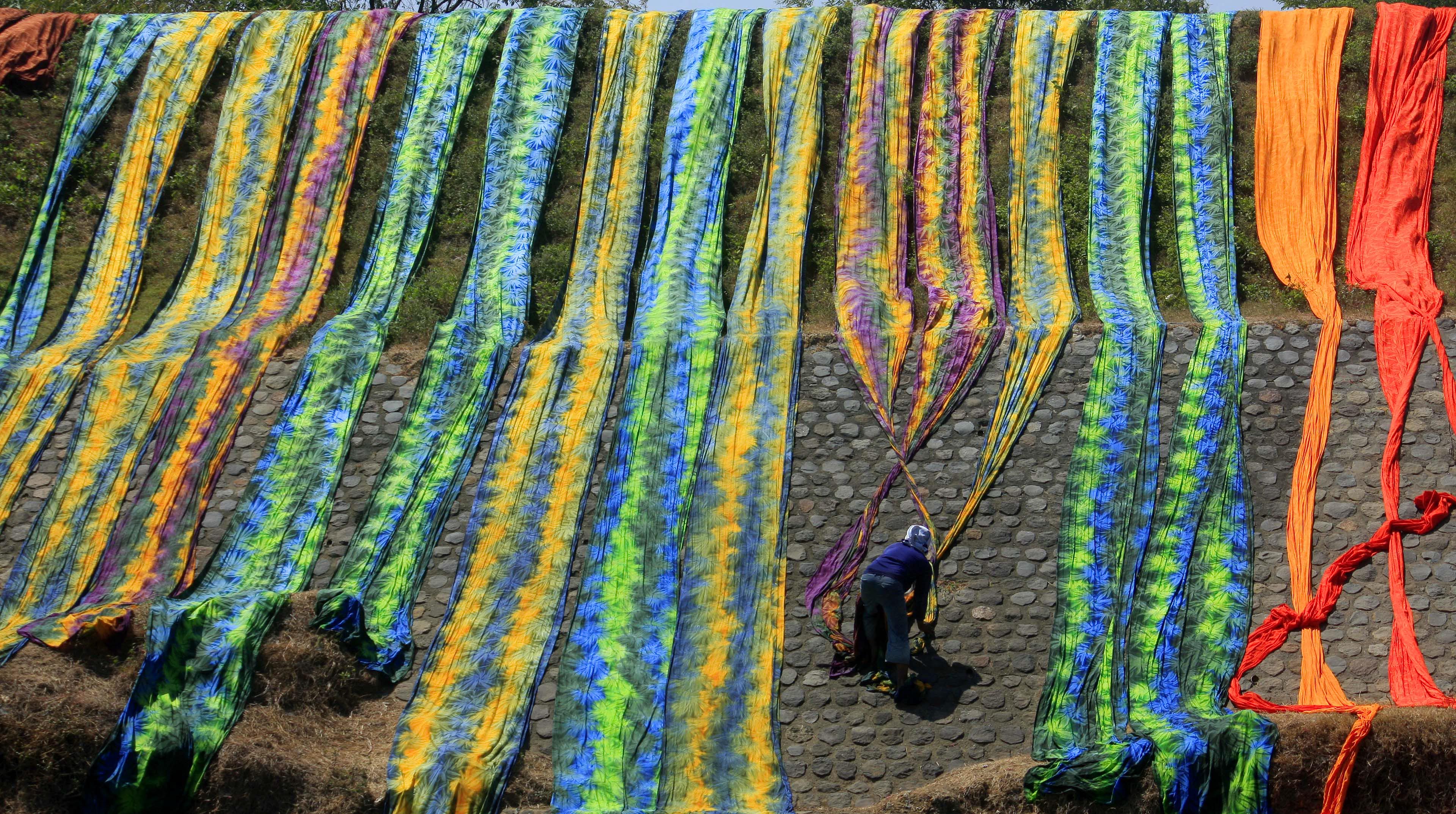 Pekerja menjemur kain pantai setelah diwarnai di Krajan, Mojolaban, Sukoharjo. Kain pantai dijual sekitar Rp220 ribu per kodi.