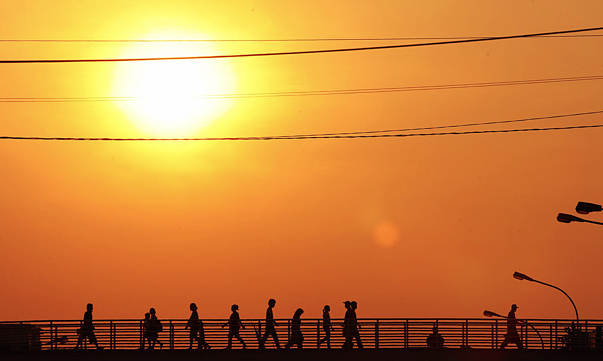 Sejumlah pejalan kaki menyeberang di jembatan penyeberangan orang (JPO) yang tak beratap di Jl. Matraman Raya, Jakarta Timur.