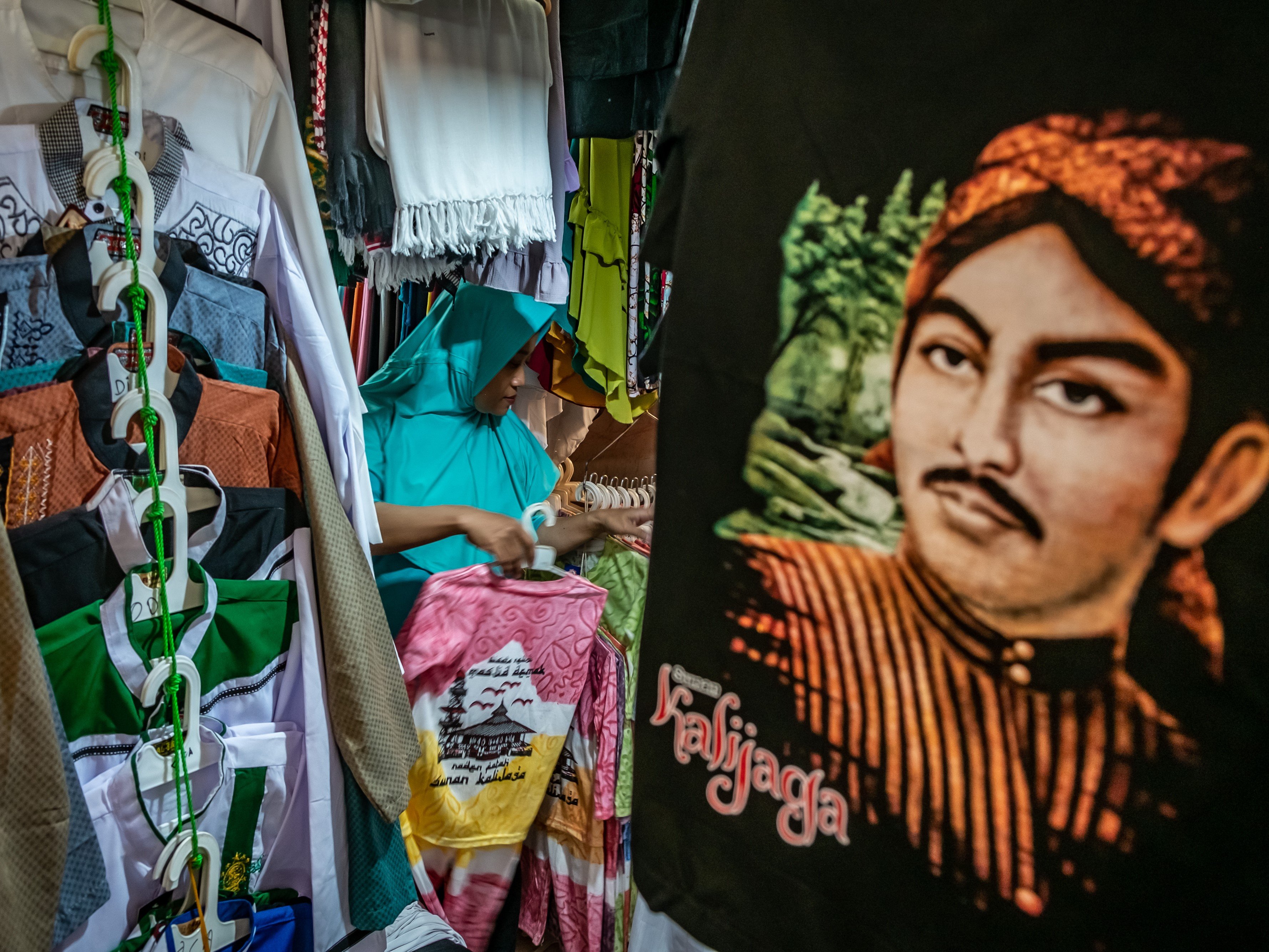 Peziarah memilih kaus di salah satu toko di Kompleks Makam Sunan Kalijaga, Kadilangu, Demak, Jawa Tengah.