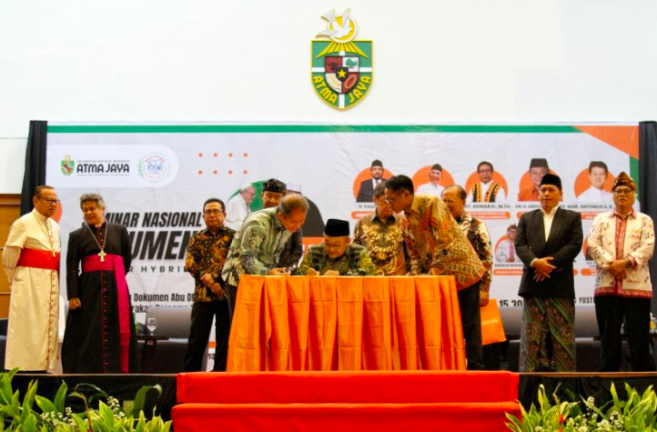 Sekretaris PP Muhammadiyah Abdul Mu'ti saat menandatangani pernyataan sikap implementasi Dokumen Abu Dhabi di Universitas Atma Jaya, Jakarta