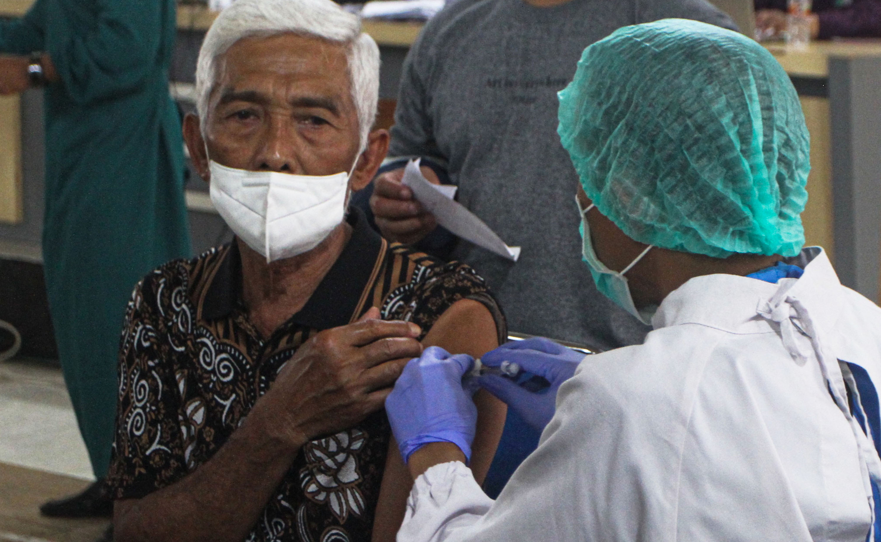 Nakes menyuntikkan vaksin covid-19 dosis keempat atau booster kedua pada seorang lansia di Aula Kelurahan Pandanwangi, Malang, Jawa Timur.