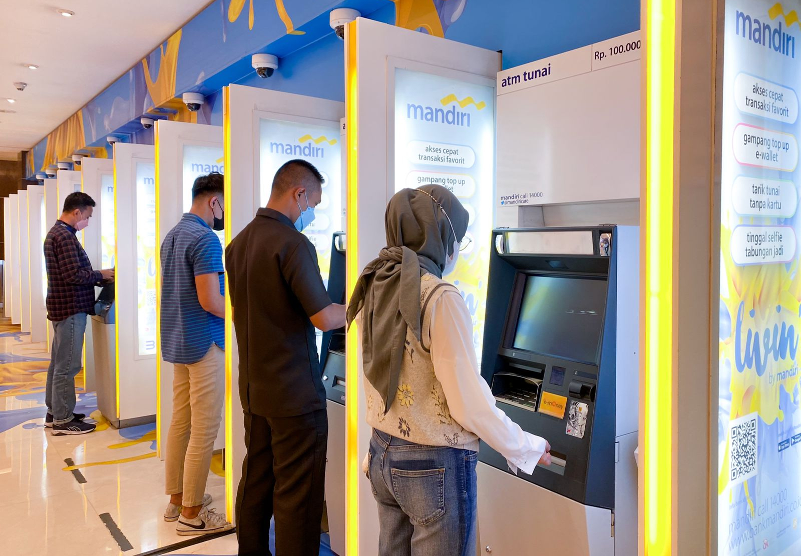 Nasabah melakukan transaksi keuangan di mesin ATM Bank Mandiri di Jakarta.