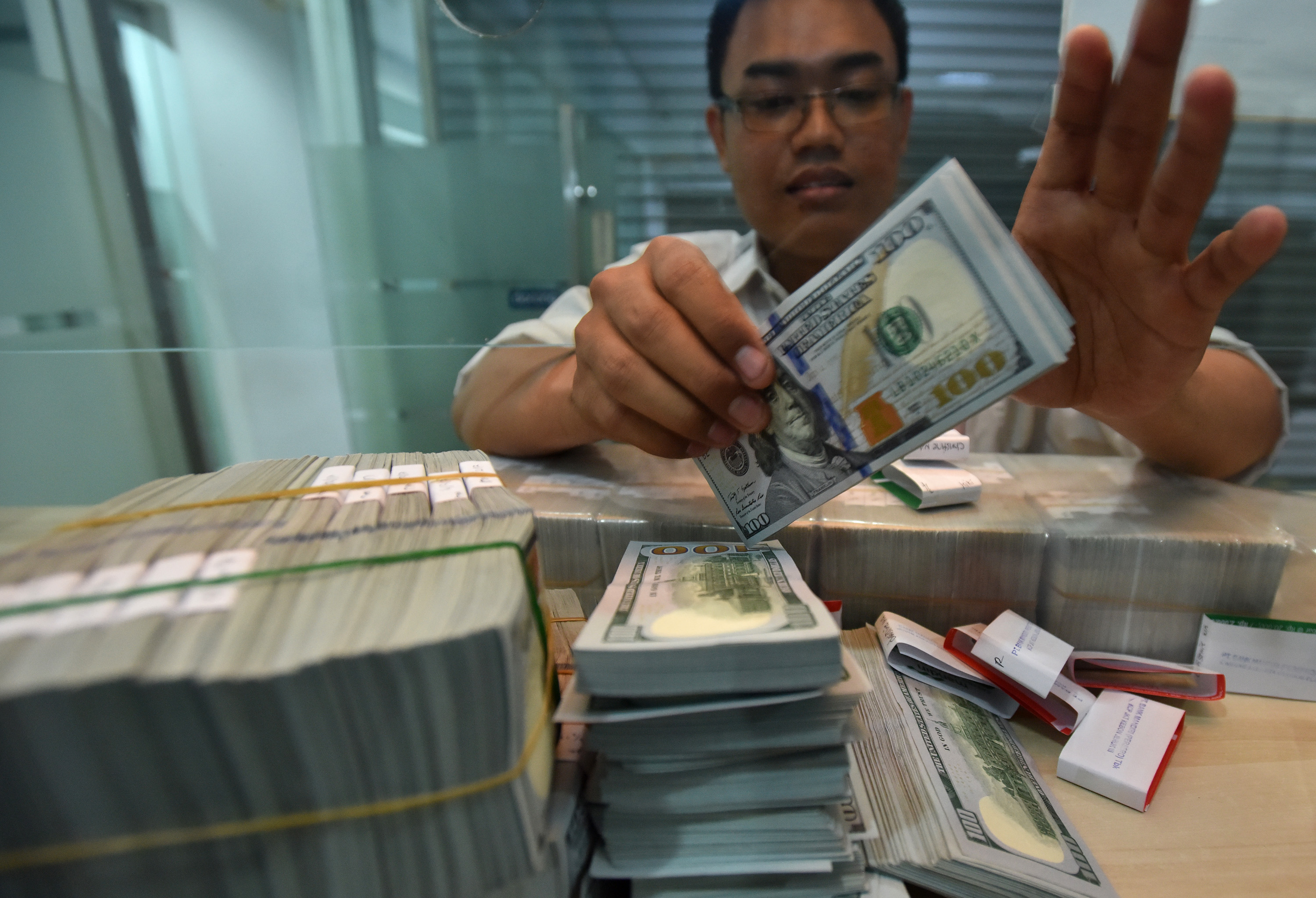 Petugas menghitung uang dollar AS