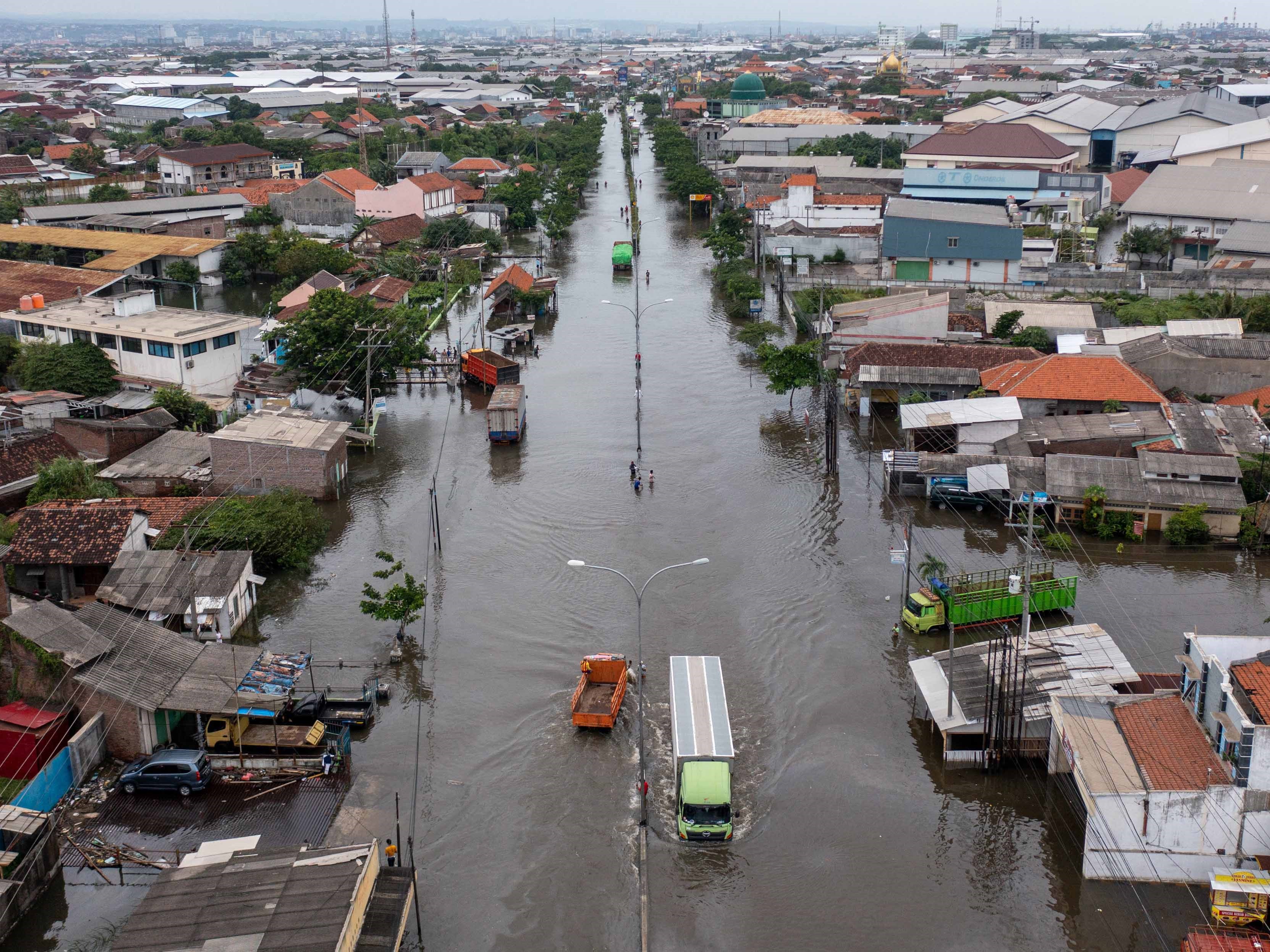 Foto udara truk menerjang banjir yang merendam Jalur Pantura Kaligawe-Genuk, Semarang, Jawa Tengah, Senin (2/1/2023).