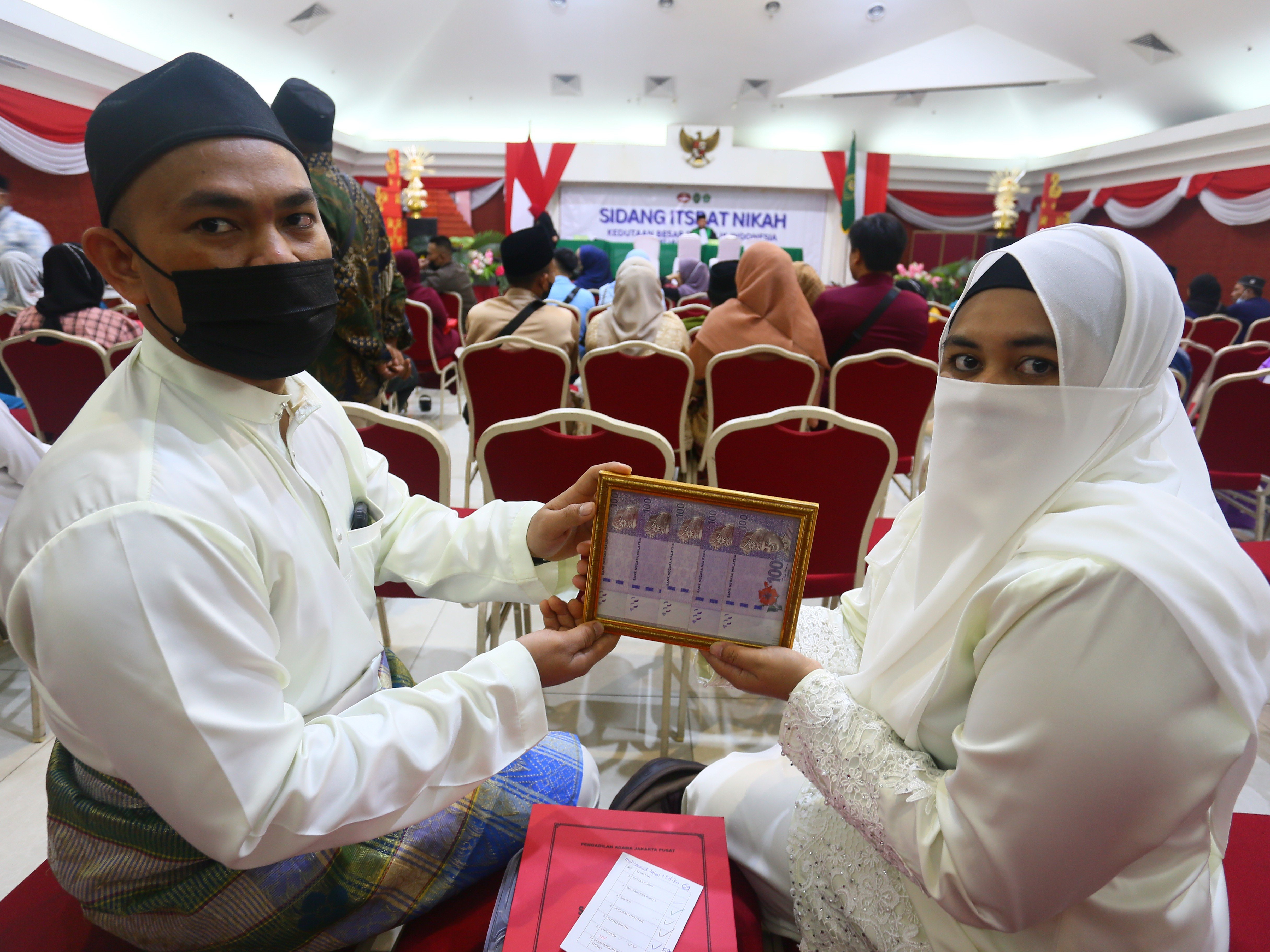 Pasangan suami istri Efrika Rita (kanan) dan Muhammad Iqbal menunjukkan mahar pernikahan.
