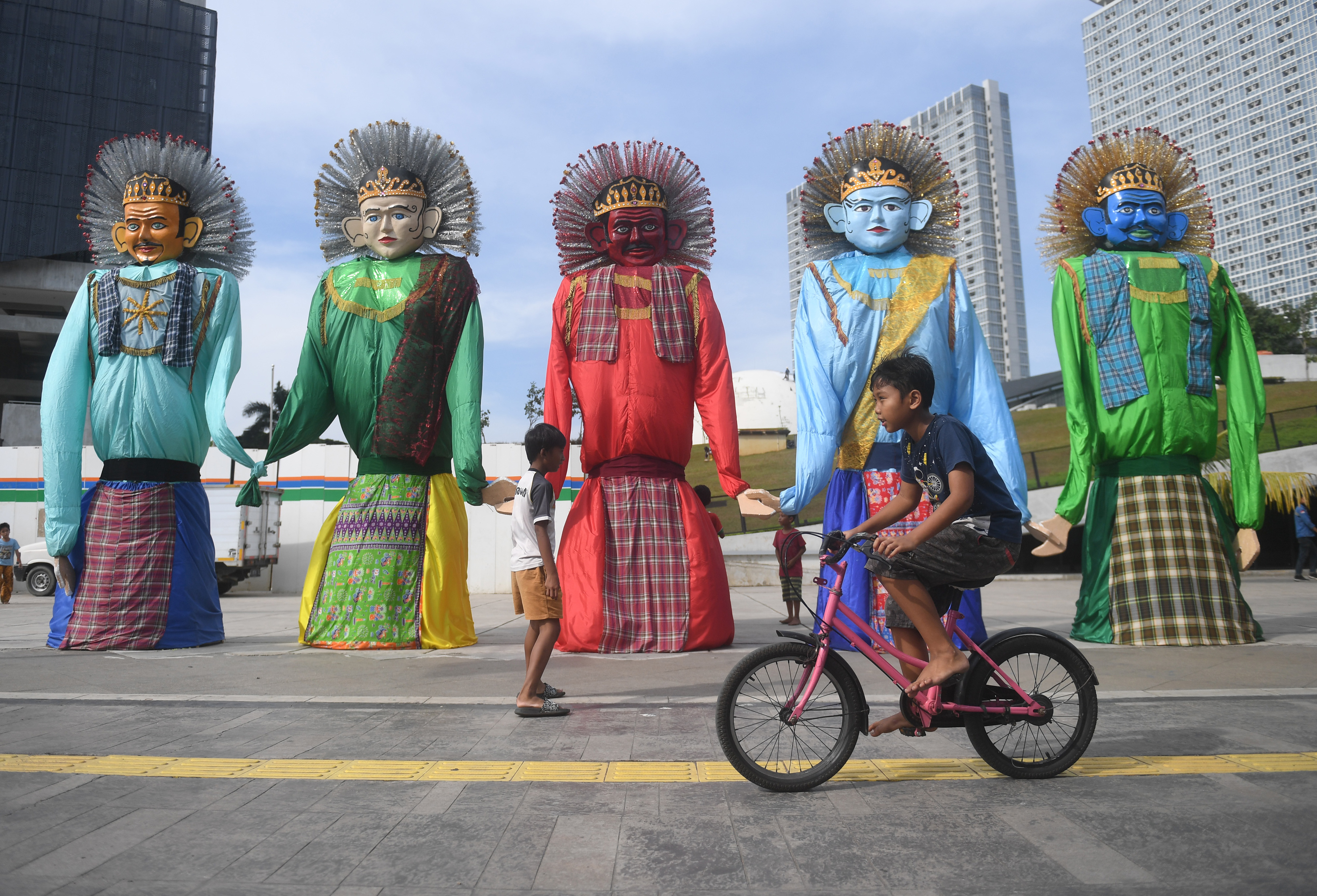Sejumlah anak bermain di dekat instalasi ondel-ondel yang dipamerkan di kawasan TIM, Jakarta.