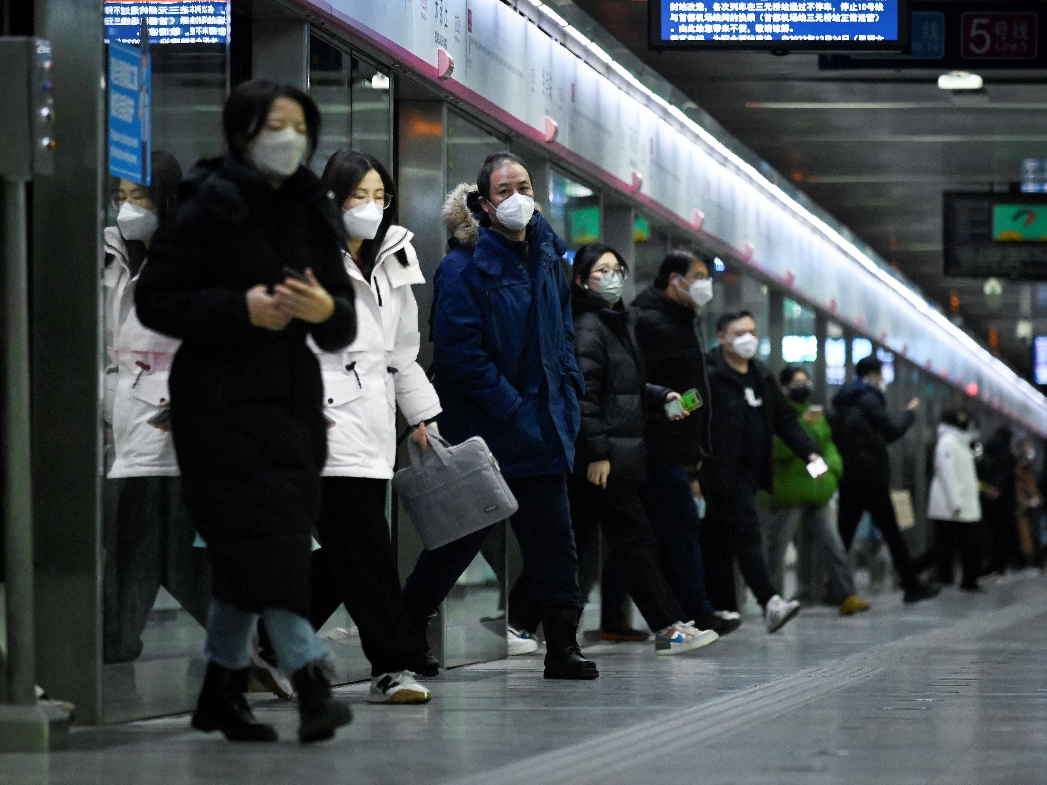Komuter keluar dari kereta di stasiun kereta bawah tanah di Beijing pada 17 Januari 2023. 