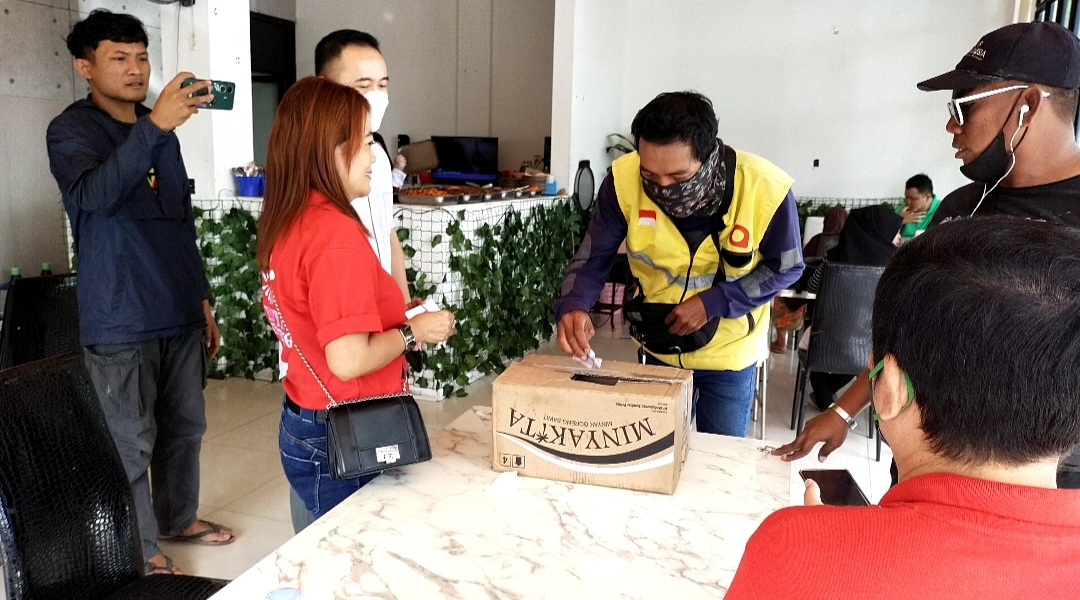 Pengemudi ojol saat memasukan uang seikhlasnya untuk mendapat kupon makan, dalam kegiatan Baksos Imlek Jumat Barokah, Jumat (20/1)