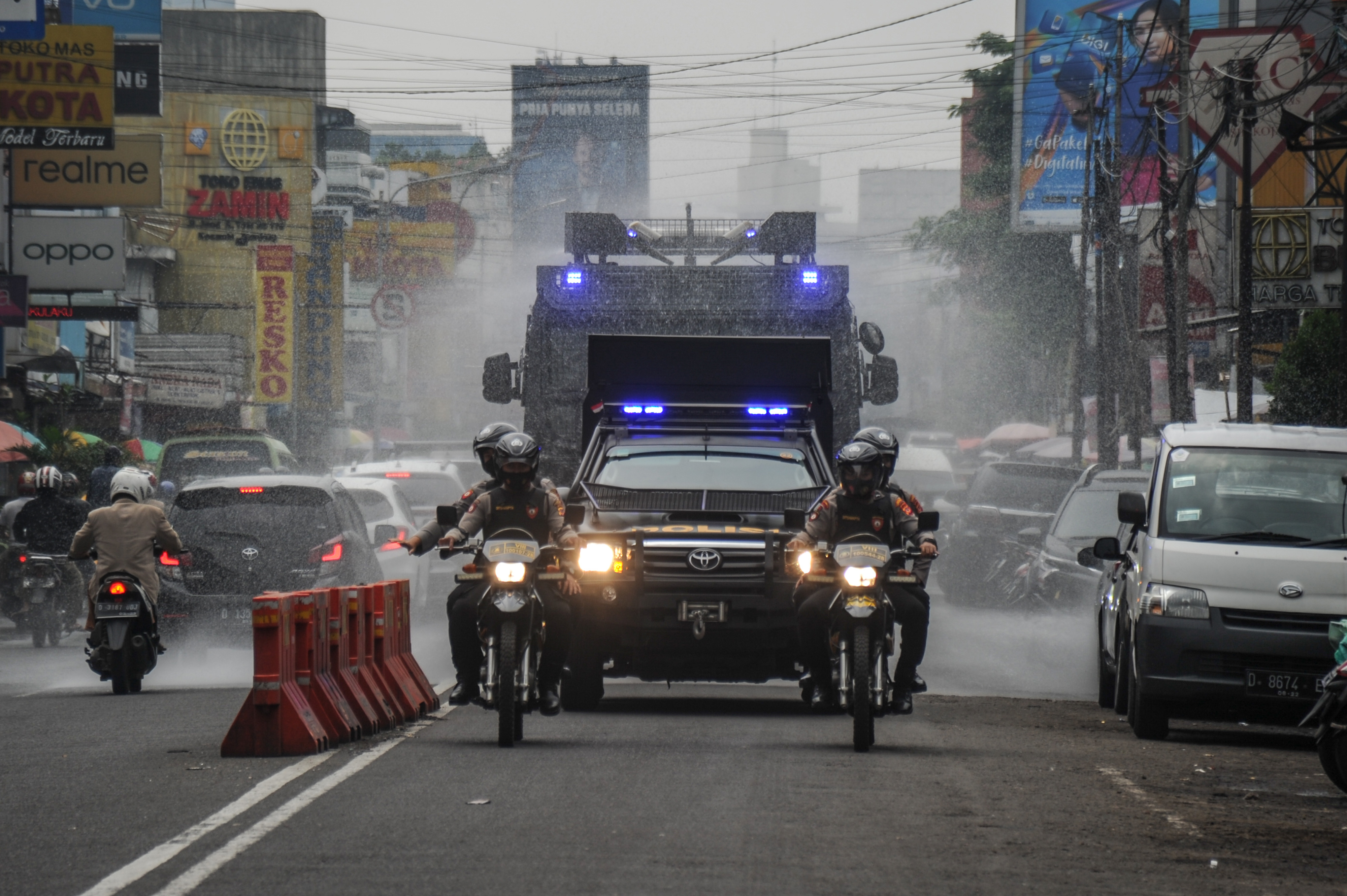 Petugas Polrestabes Bandung melakukan patroli kerumunan dan menyemprotkan disinfektan di Jalan Ahmad Yani, Bandung, Sabtu (19/2/2022). 