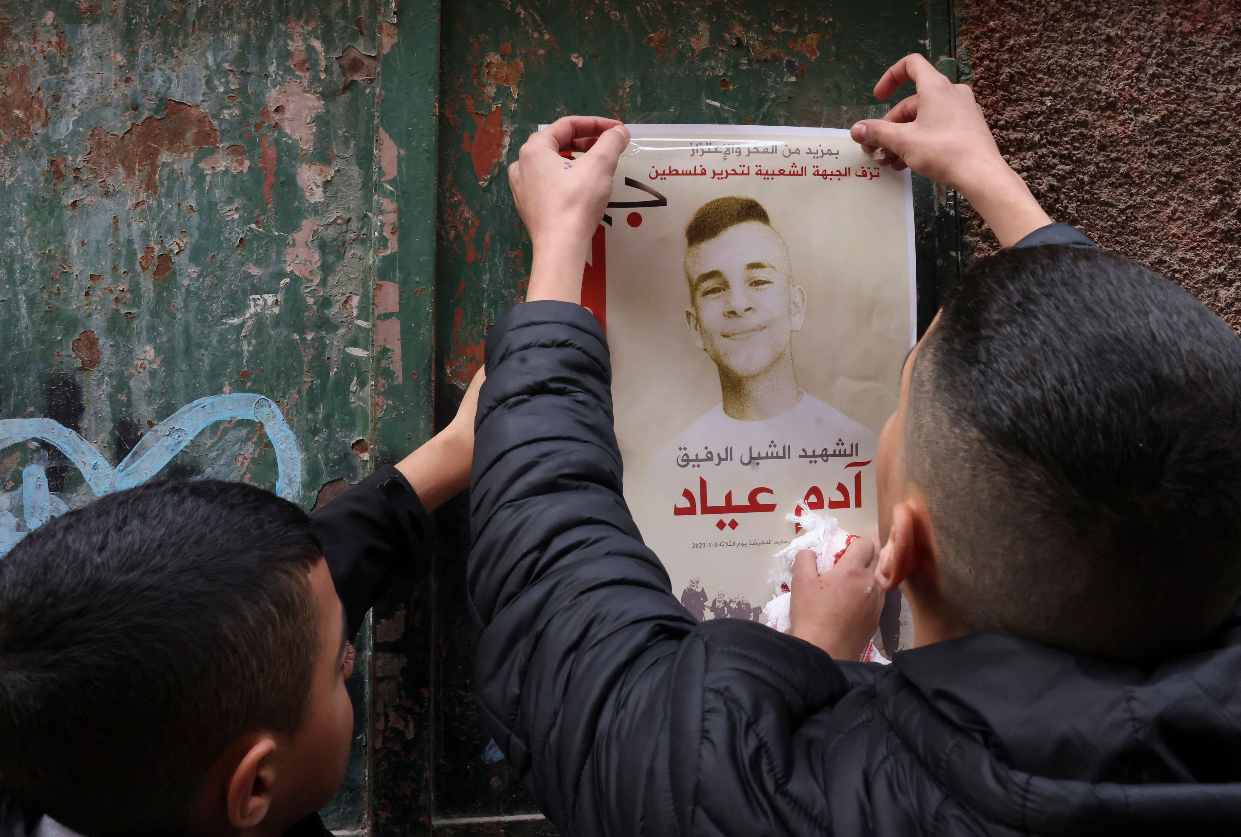 Warga Israel menempelkan poster bergambar remaja yang menjadi korban penembakan tentara Israel di Betlehem, Tepi Barat, Selasa (3/1).