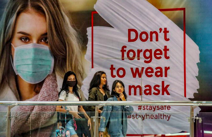 Pengunjung melewati imbauan mengenakan masker saat mengunjungi pusat perbelanjaan Pondok Indah Mall, Jakarta.