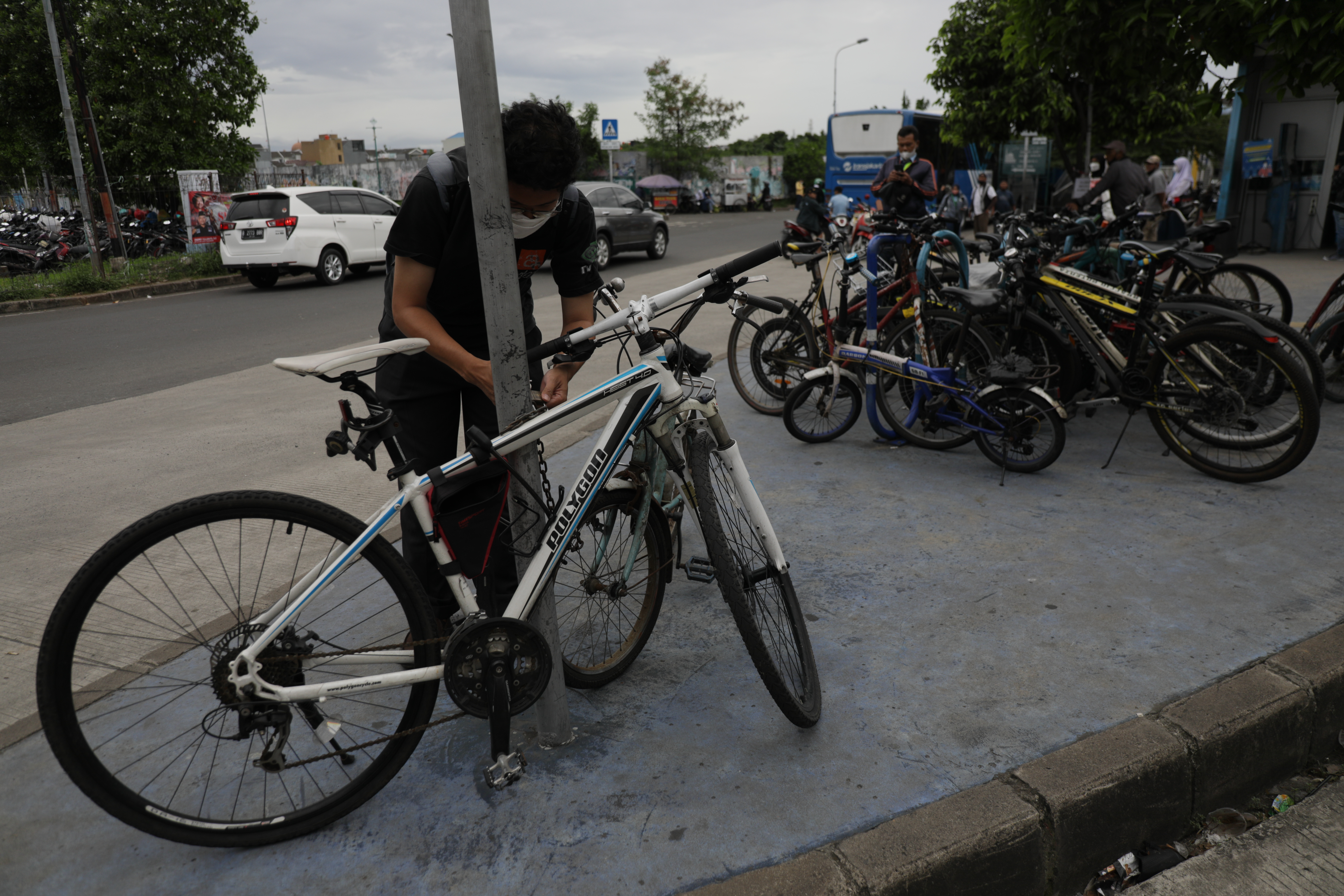 Pengguna bus TransJakarta meletakkan sepeda miliknya di depan halte Bus TransJakarta, Puri Beta 1, Kota Tangerang.