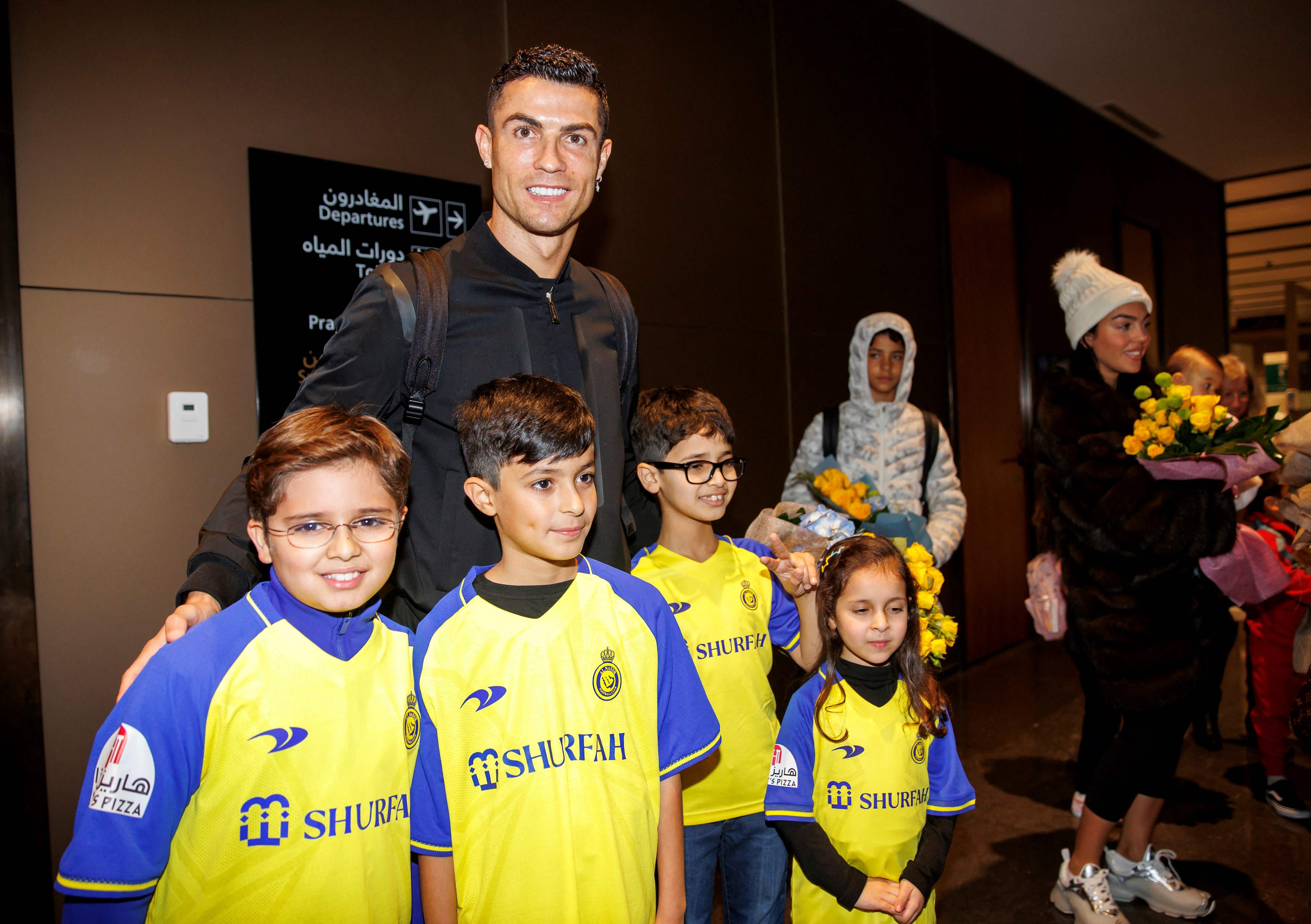 Cristiano Ronaldo berpose dengan sejumlah anak yang mengenakan jersey Al Nassr saat tiba di bandara di Riyadh, Arab Saudi.