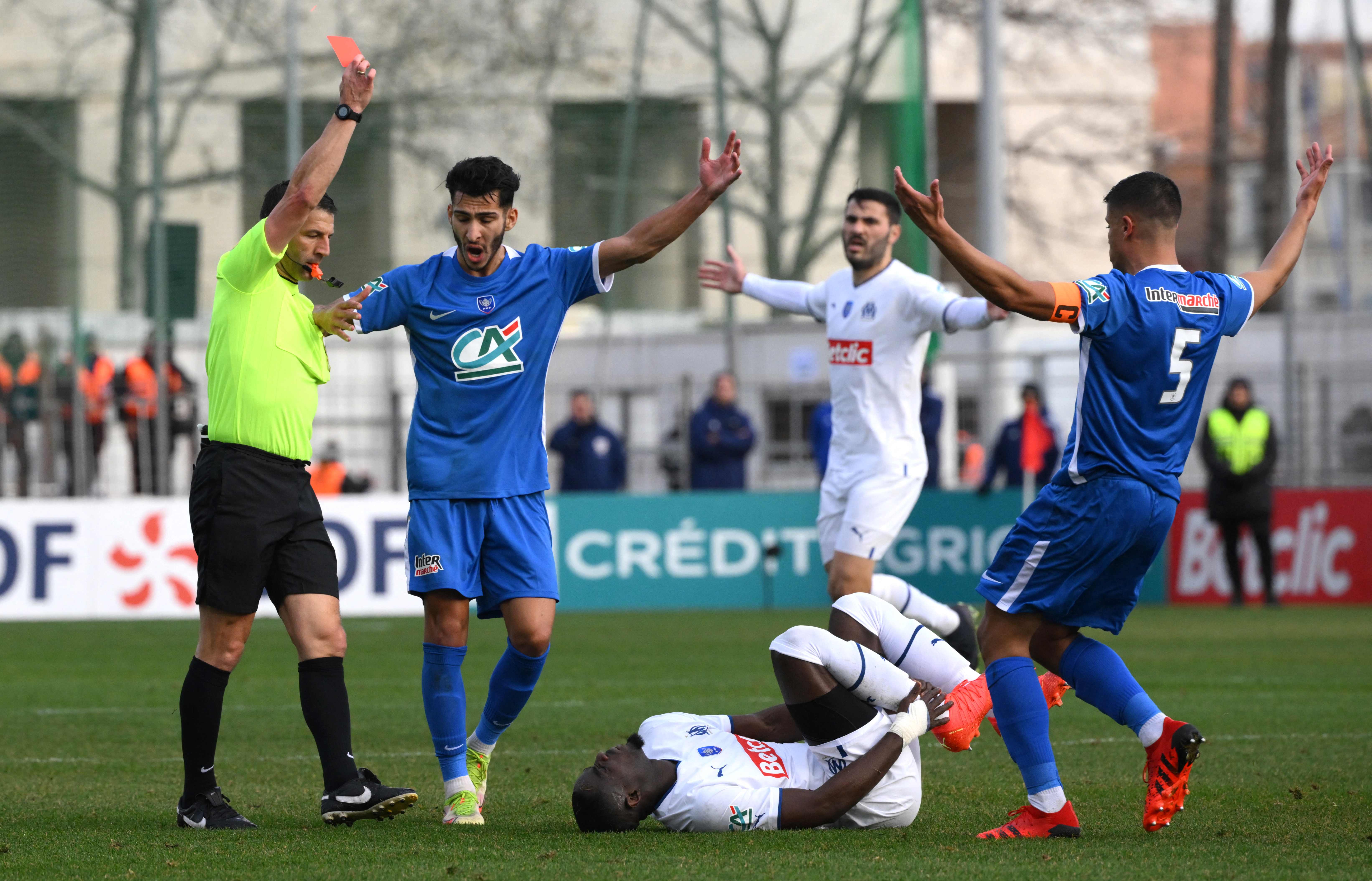 Wasit memberikan kartu merah kepada bek Marseille Eric Bailly (terbaring) setelah melakukan pelanggaran keras di laga Coupe de France.