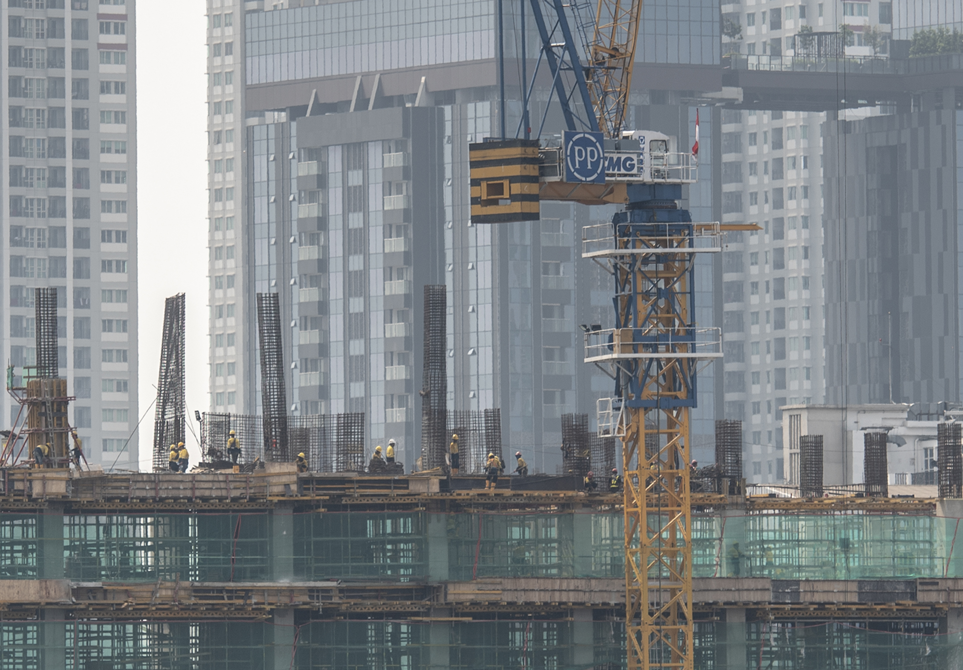 Potret pekerja menyelesaikan pembangunan gedung bertingkat di Jakarta.