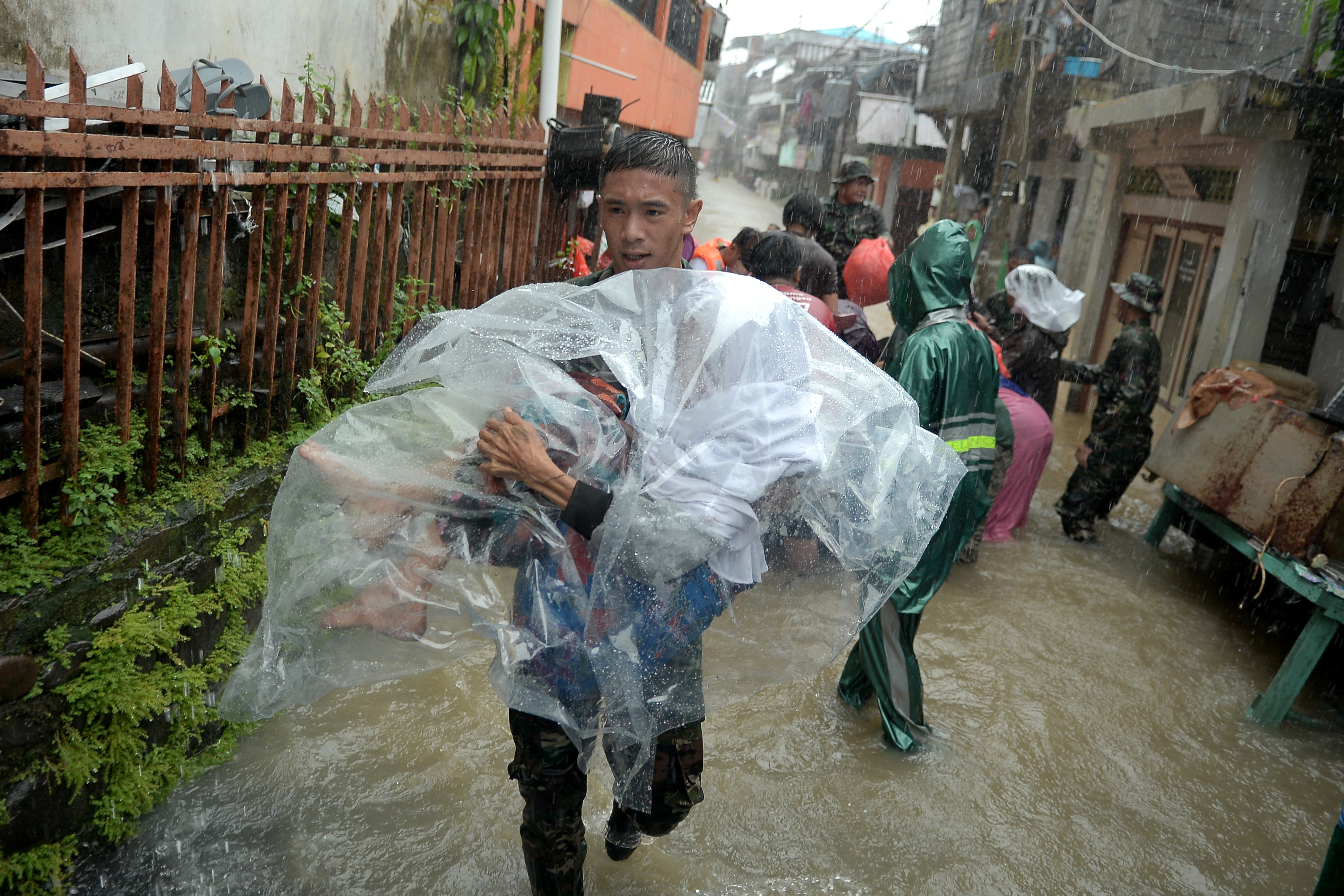Anggota TNI menggendong seorang warga lansia dari rumahnya yang terendam banjir di Manado, Sulawesi Utara, Jumat (27/1).