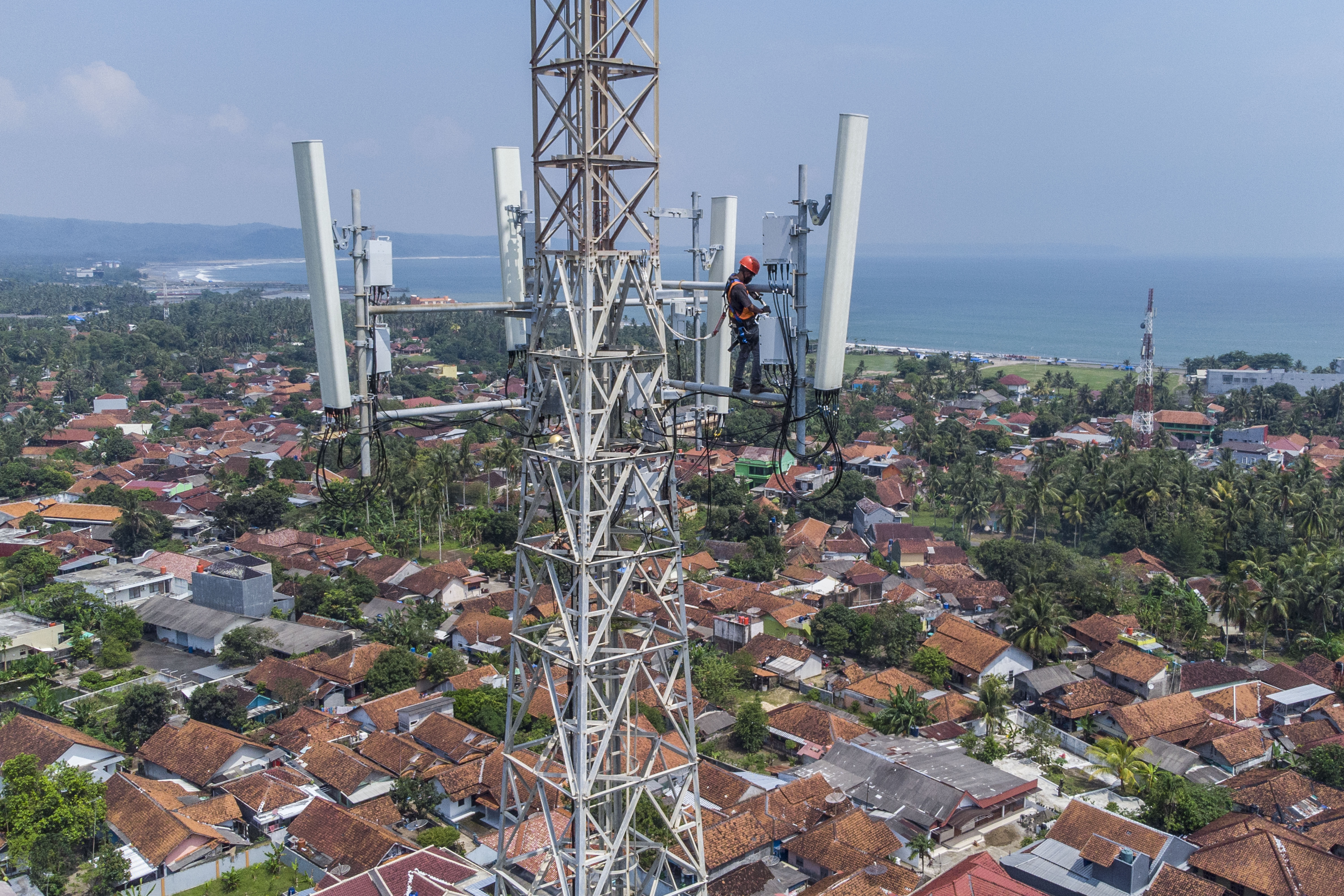 Foto udara teknisi melakukan perawatan Base Transceiver Station (BTS) XL Axiata di Pantai Barat, Desa Pananjung, Pangandaran, Jawa Barat.