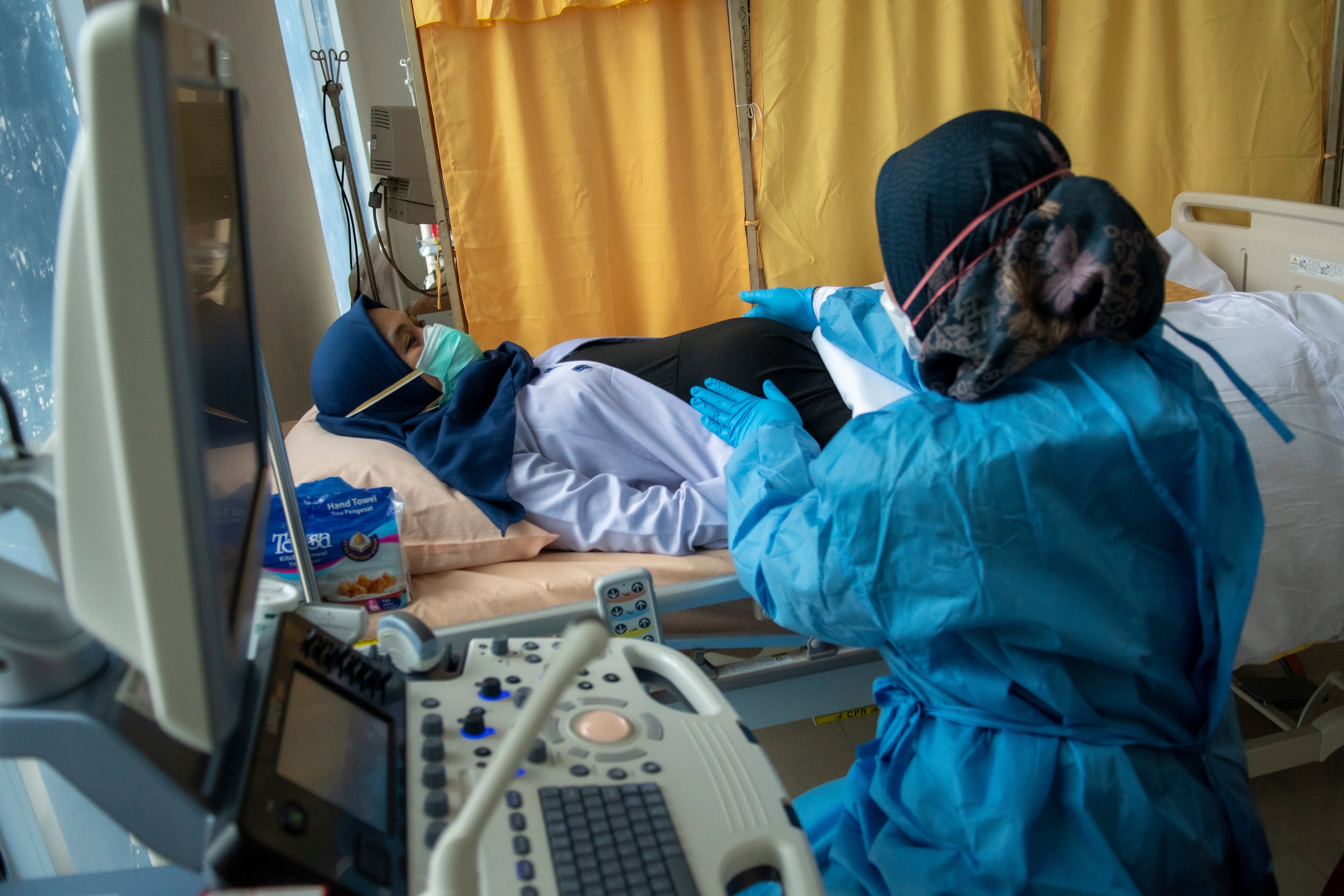 Petugas kesehatan melakukan pemeriksaan ultrasonografi (USG) kepada ibu hamil 