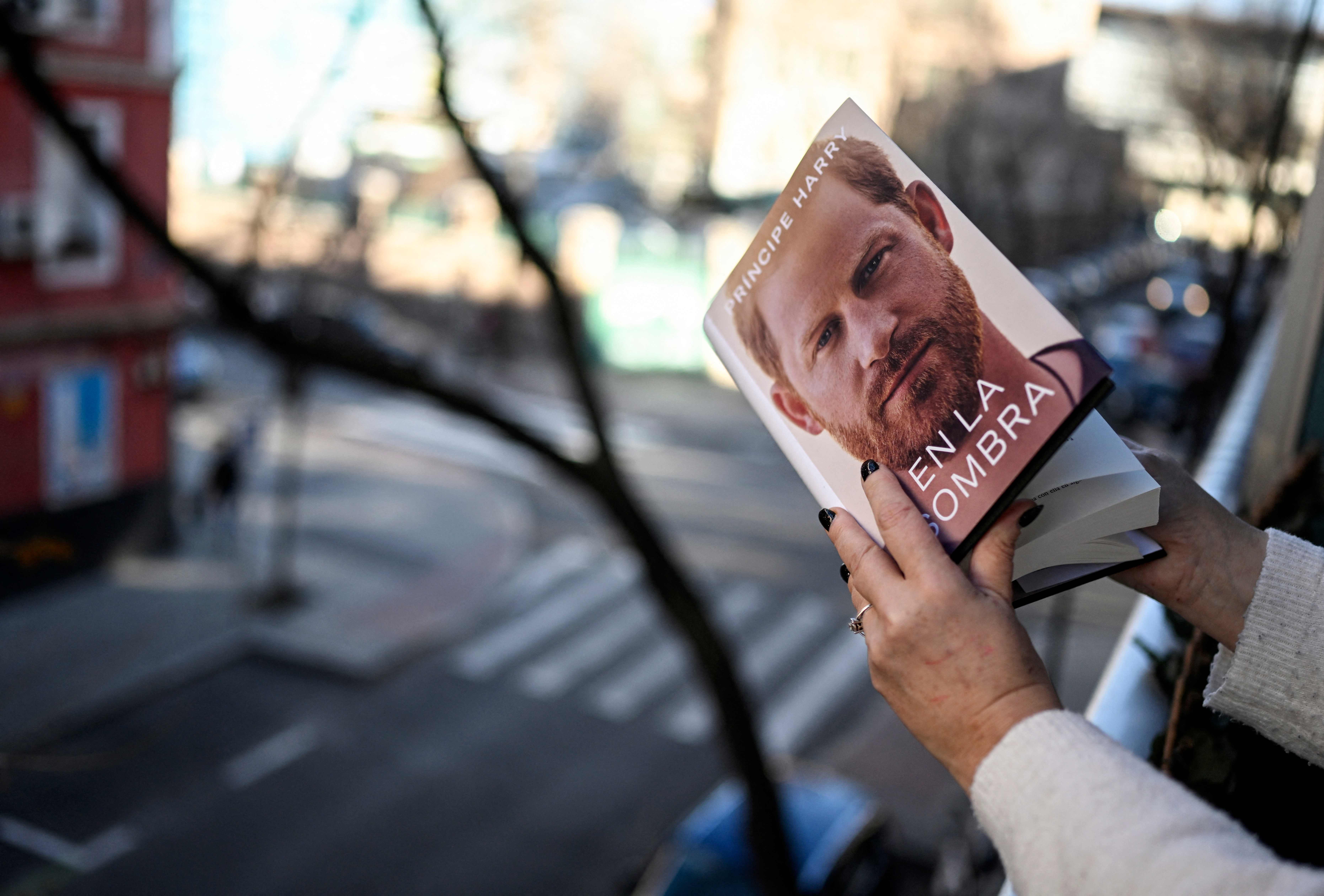 Seorang warga memegang versi bahasa Spanyol dari buku Pangeran Harry.