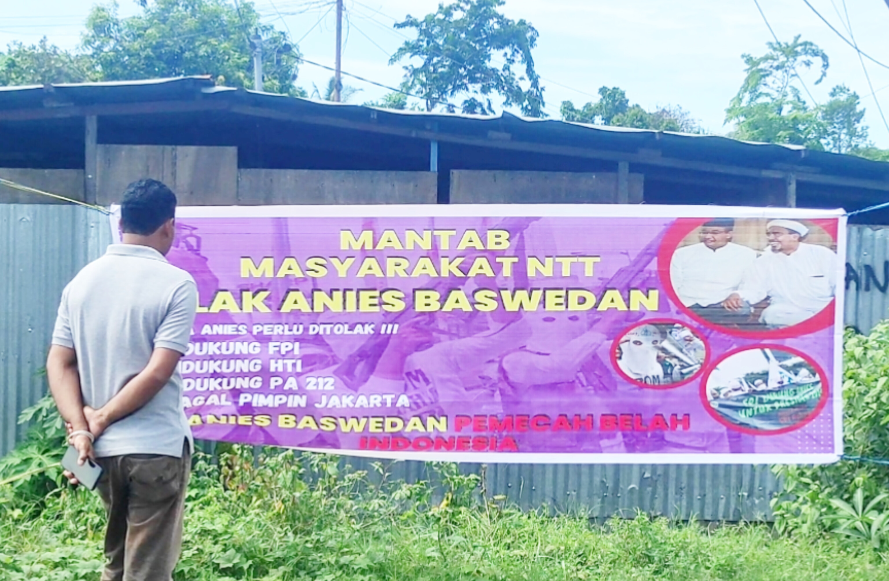 Warga membaca spanduk SARA menolak Anies Baswedan yang dipasang kelompok anti demokrasi di Kabupaten Sikka, NTT.