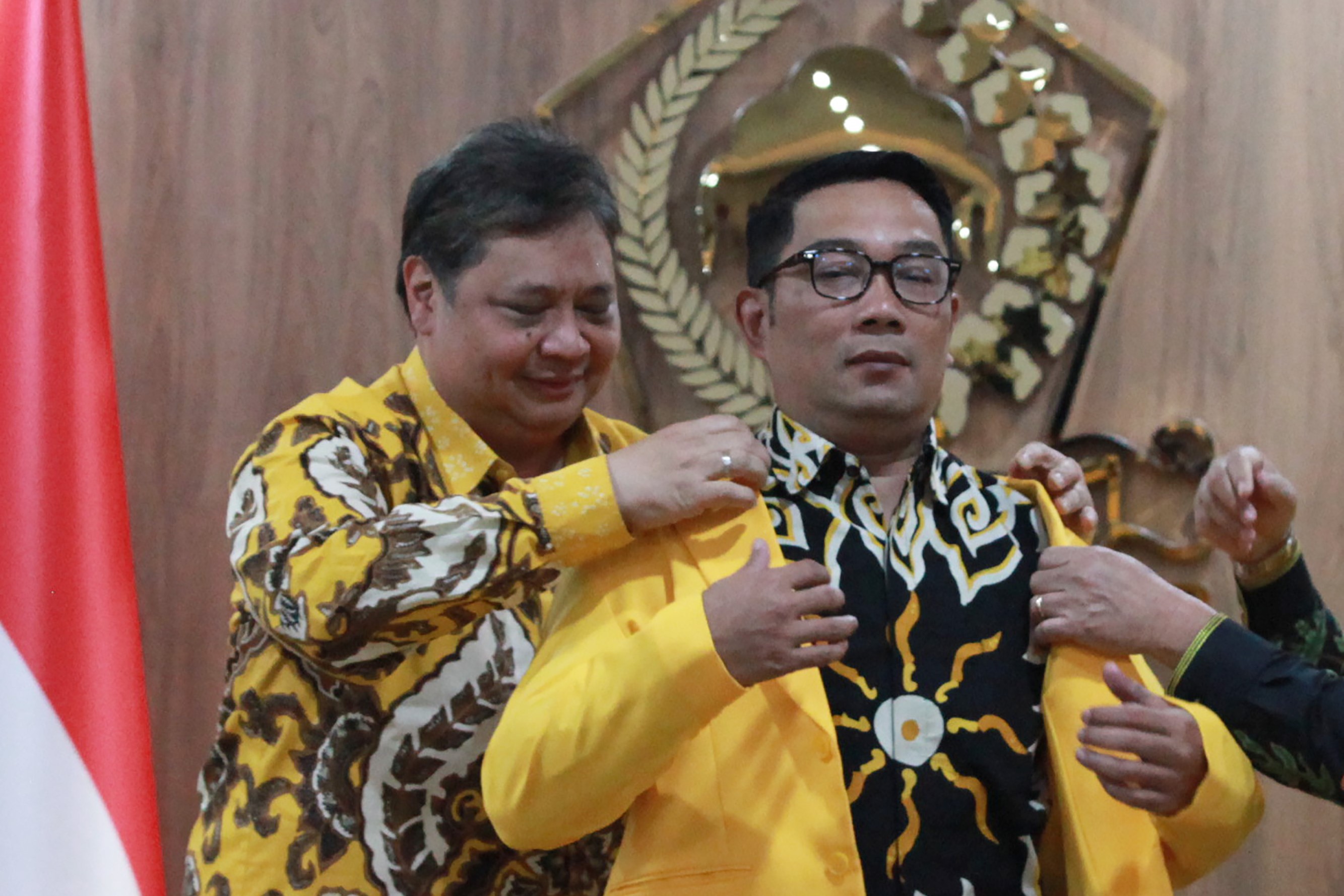 Ketua Umum Golkar Airlangga Hartarto membantu mengenakan jaket Golkar kepada Gubernur Jabar Ridwan Kamil sebagai simbol bergabung ke Golkar.