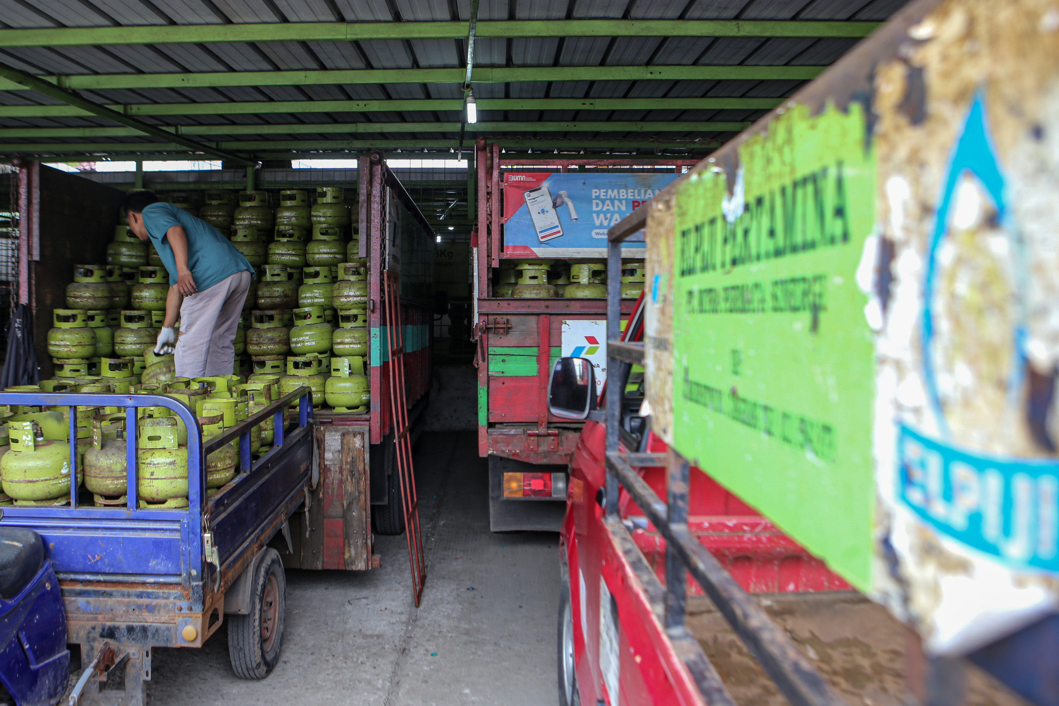 Pekerja mengangkut tabung gas elpiji 3 kg di Pangkalan Gas di Cipondoh, Kota Tangerang.