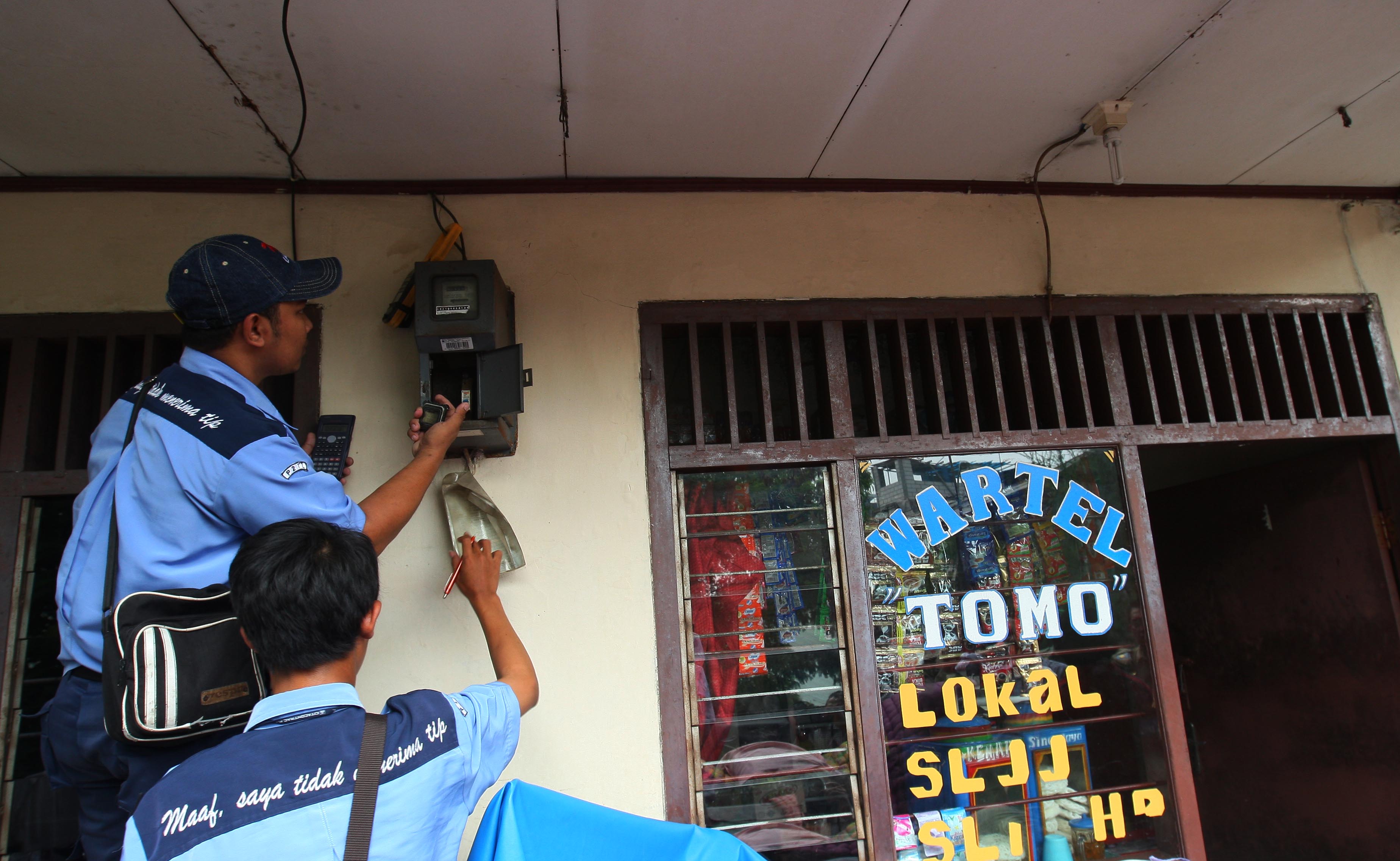 Petugas PLN memeriksa meteran listrik di perumahan padat penduduk RW.10 Kelurahan Angke, Tambora, Jakarta.