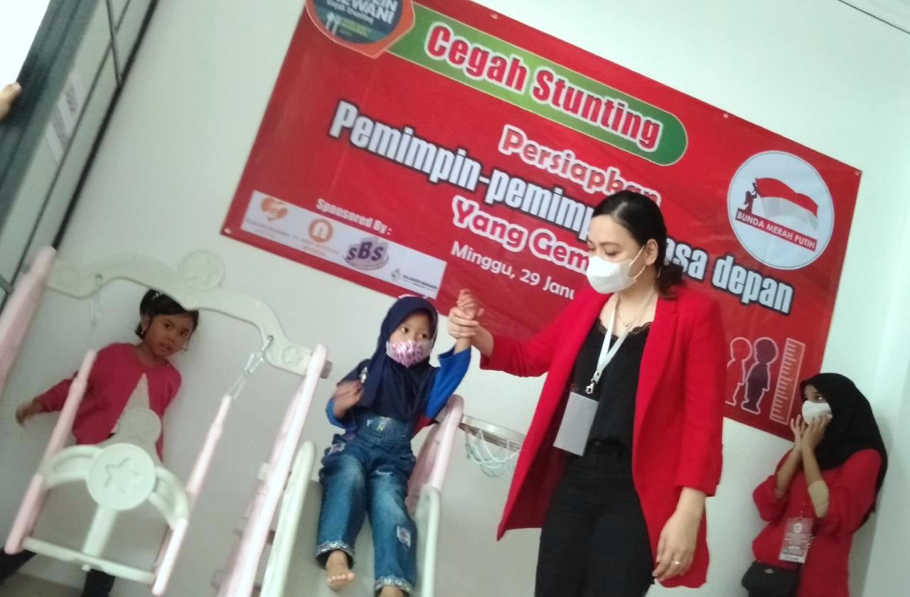 Anggota BMI bermain bersama anak-anak dalam kegiatan pencegahan stunting. 